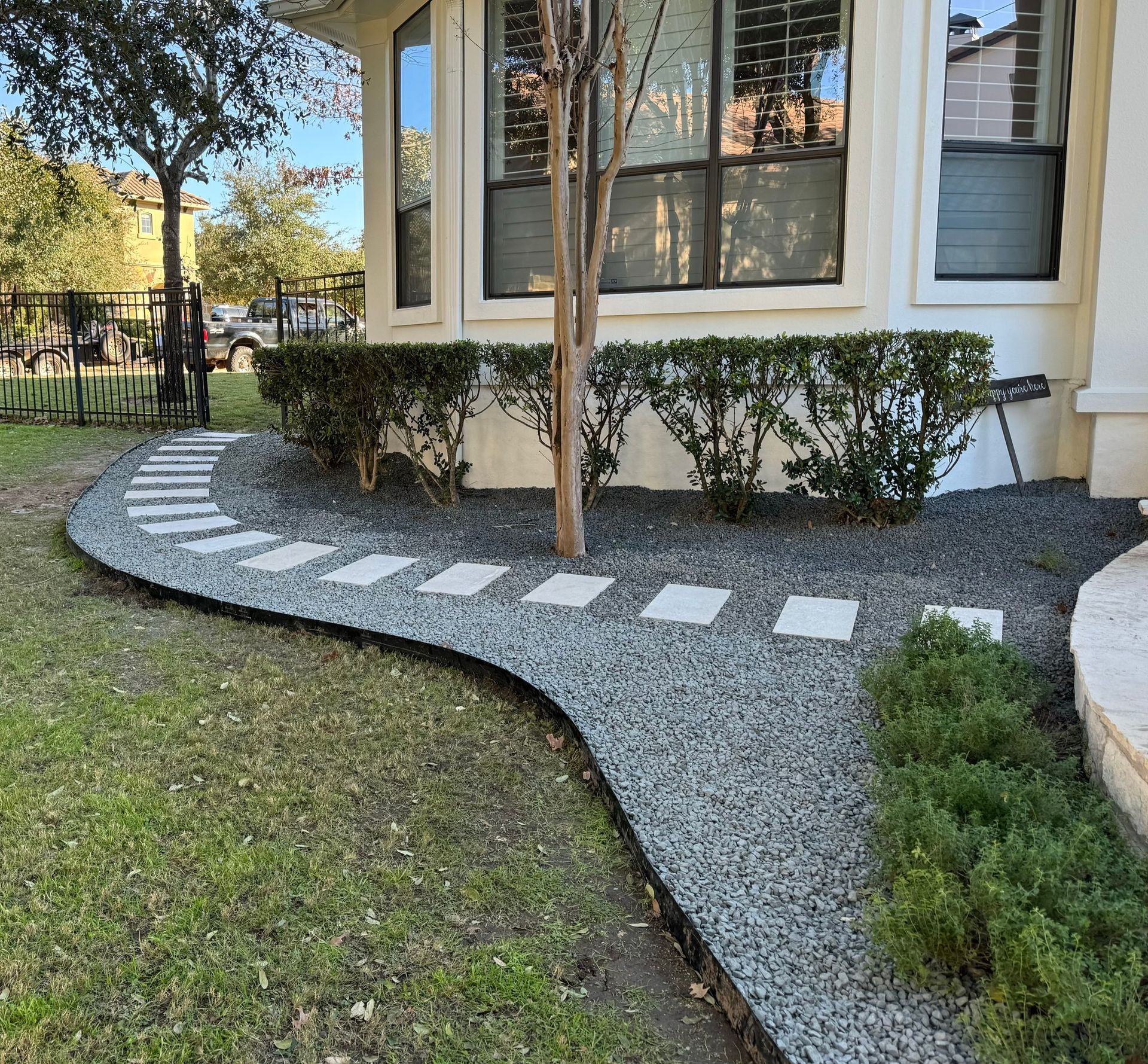 A walkway leading to a house with a tree in the middle