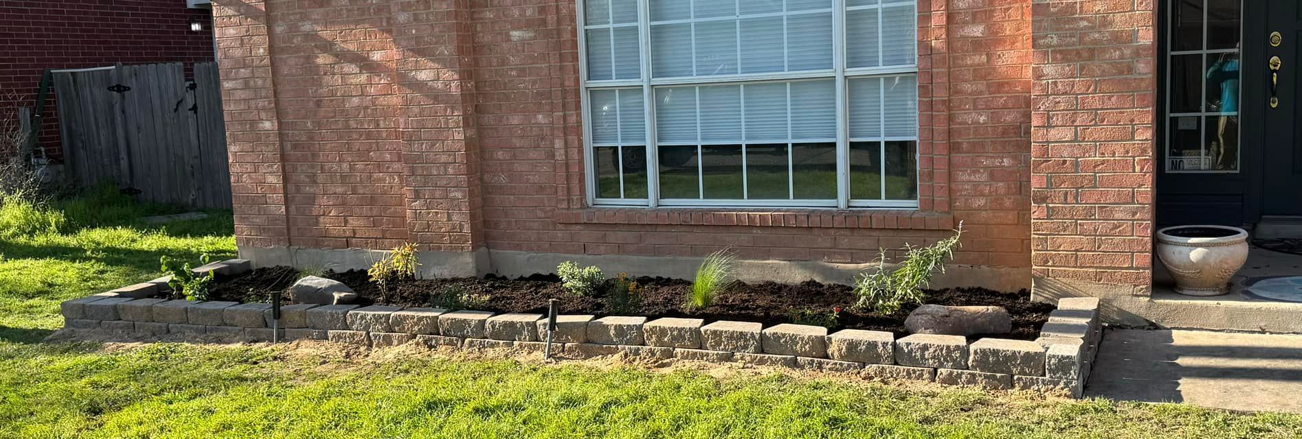 A brick house with a window and a planter in front of it.