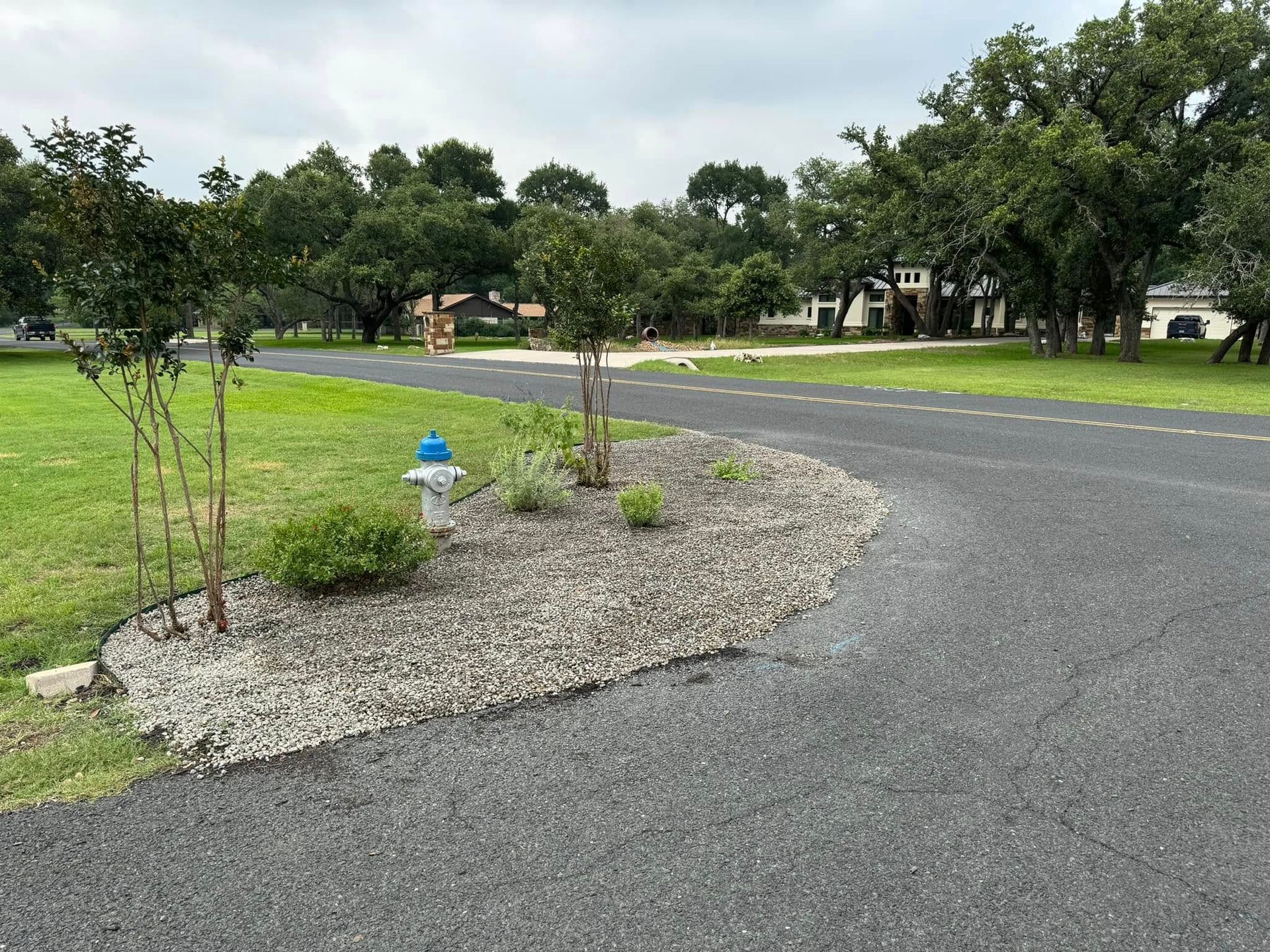 A fire hydrant on the side of a road next to a grassy area.