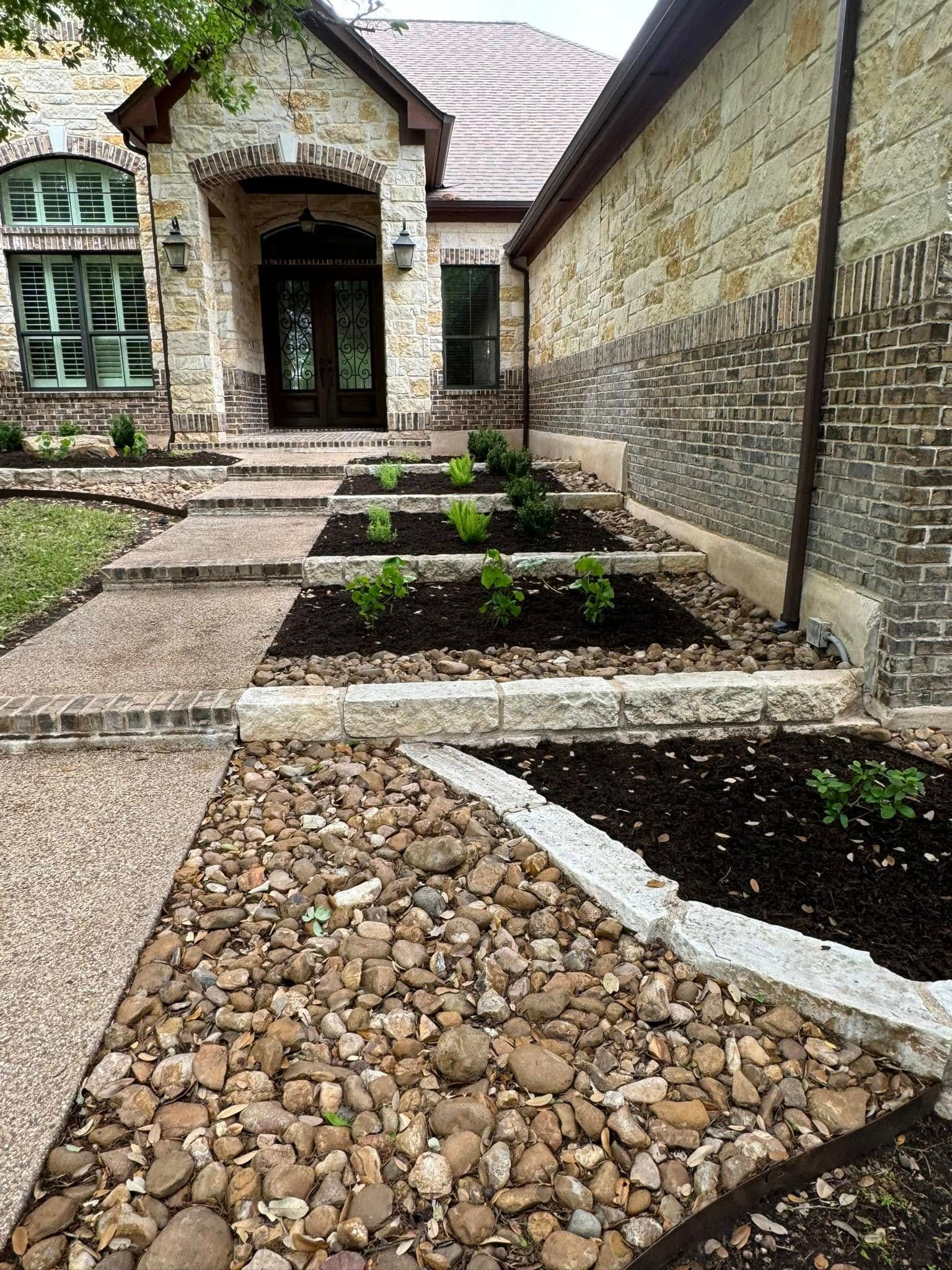 There is a stone walkway leading to the front of the house.