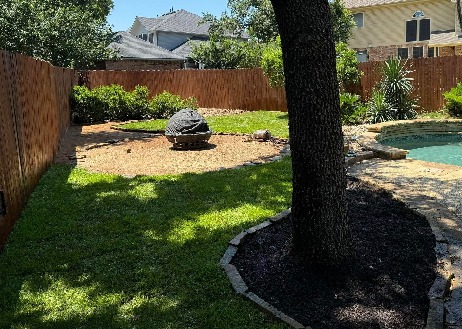 A backyard with a fire pit and a pool.