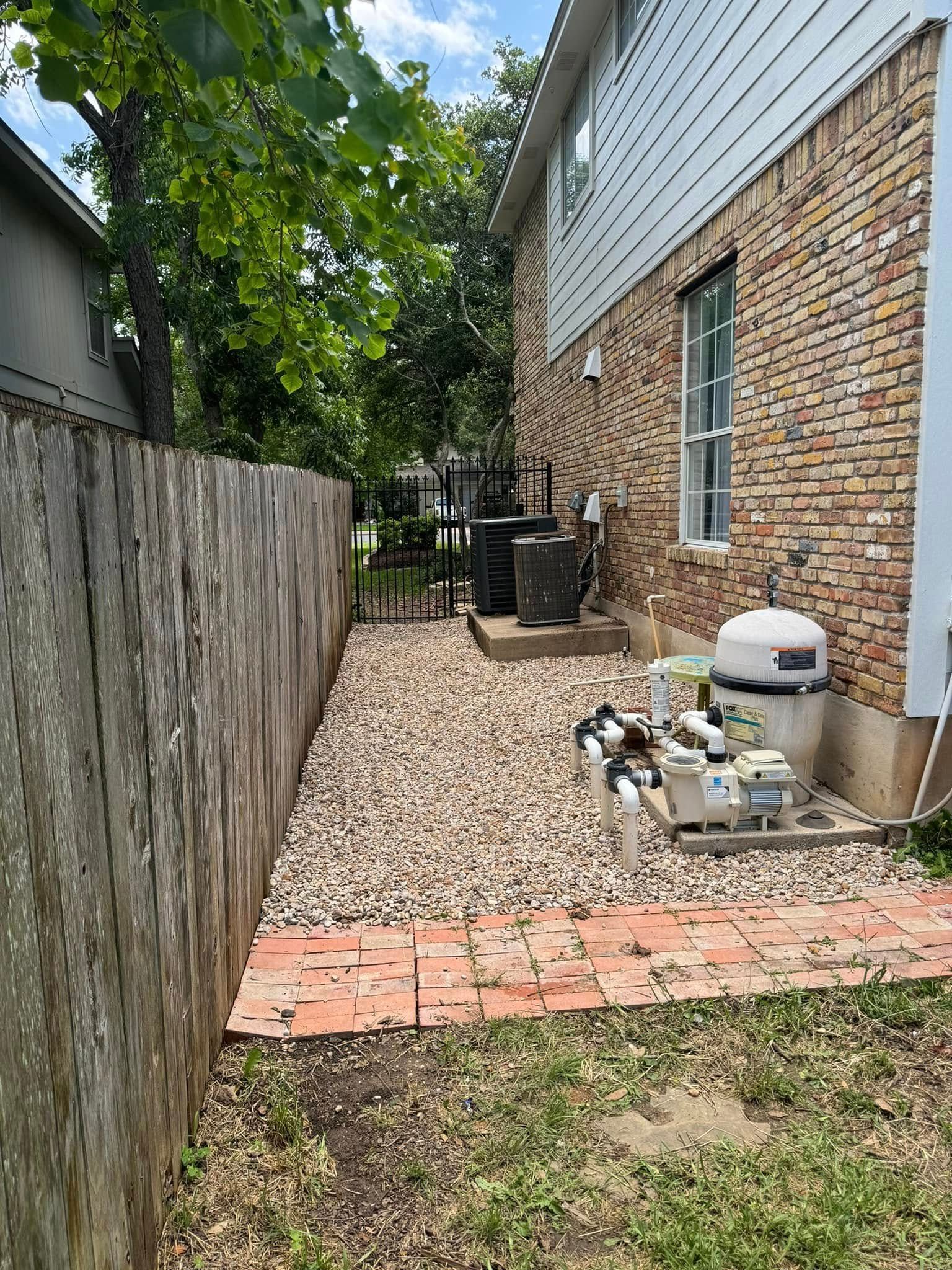 There is a wooden fence in the backyard of a house.