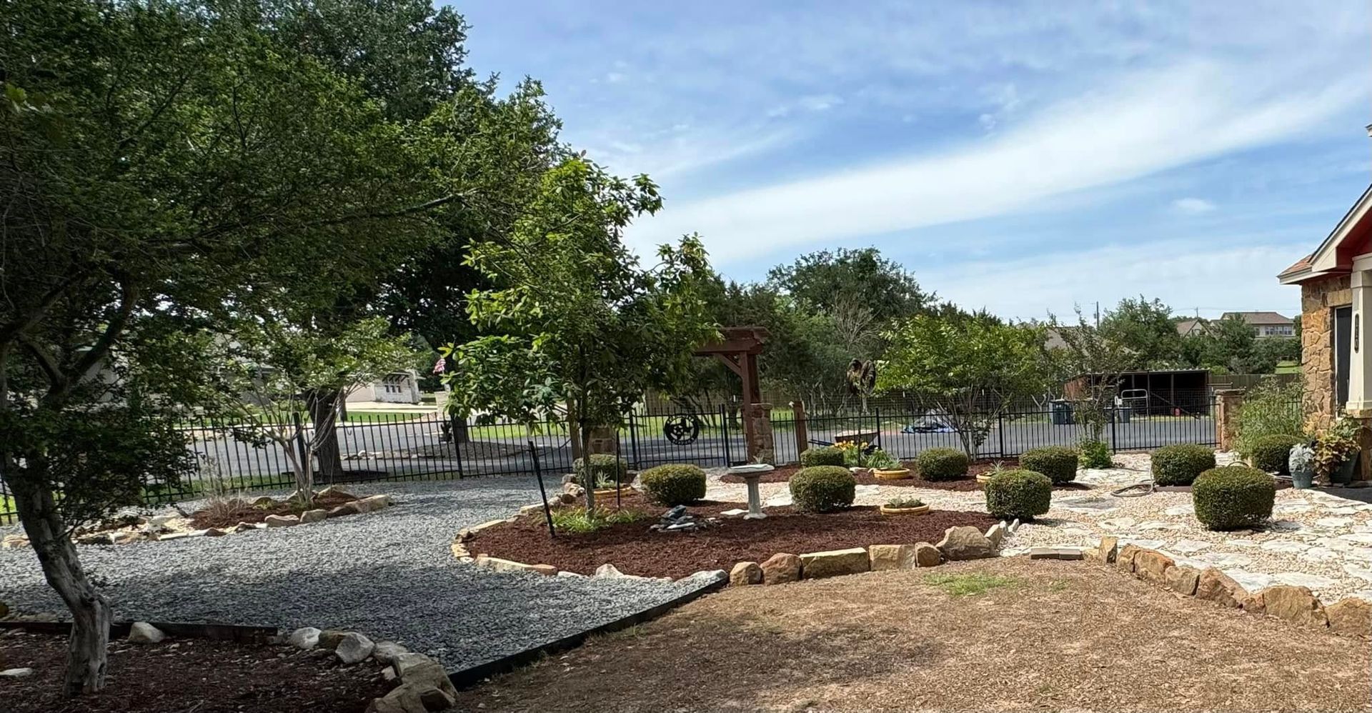A house with a lot of trees and bushes in front of it.