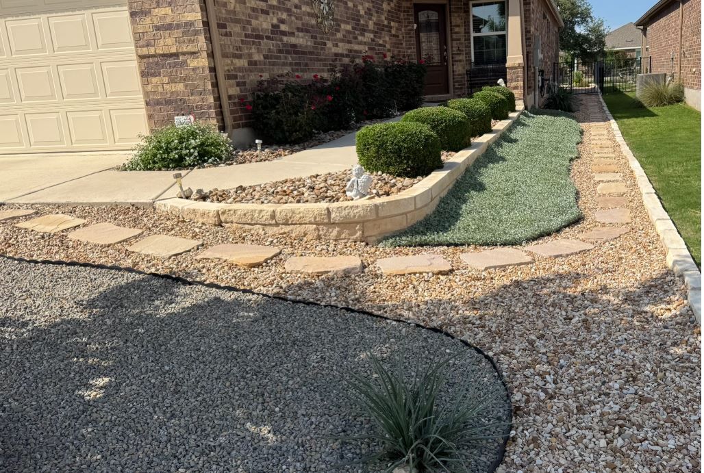 A brick house with a gravel driveway in front of it.
