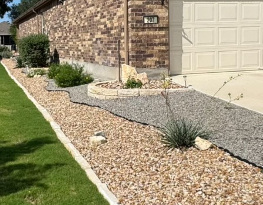 A driveway leading to a house with gravel and plants.