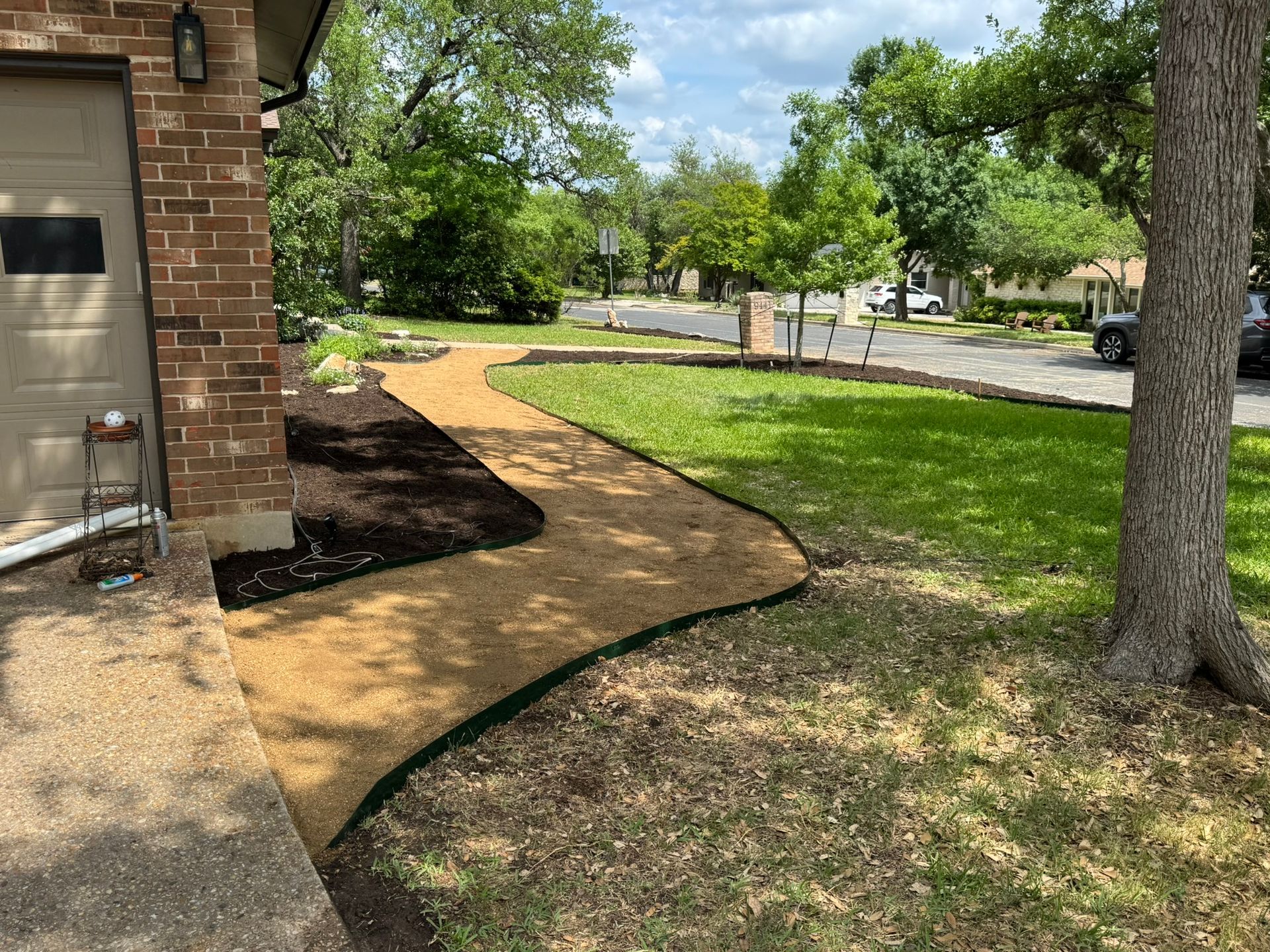 A walkway leading to a house in a residential neighborhood.