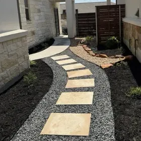 A walkway with stepping stones leading to a house.