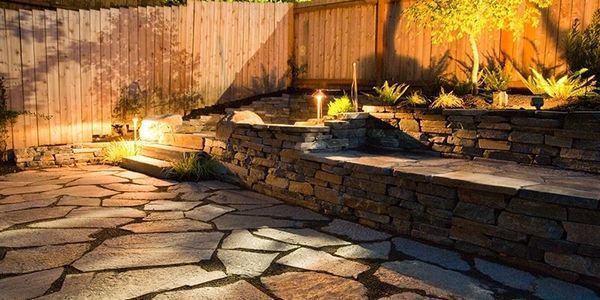 A stone patio with a wooden fence in the background.