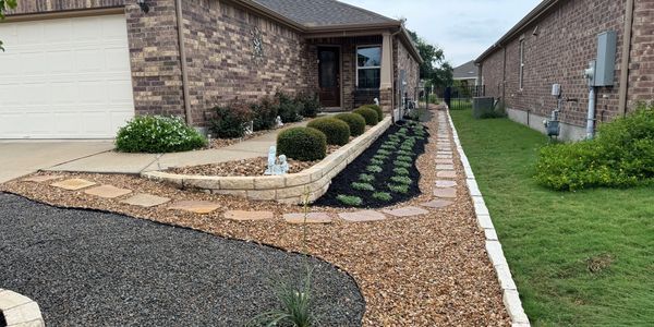 A brick house with a lush green lawn and a walkway leading to it.