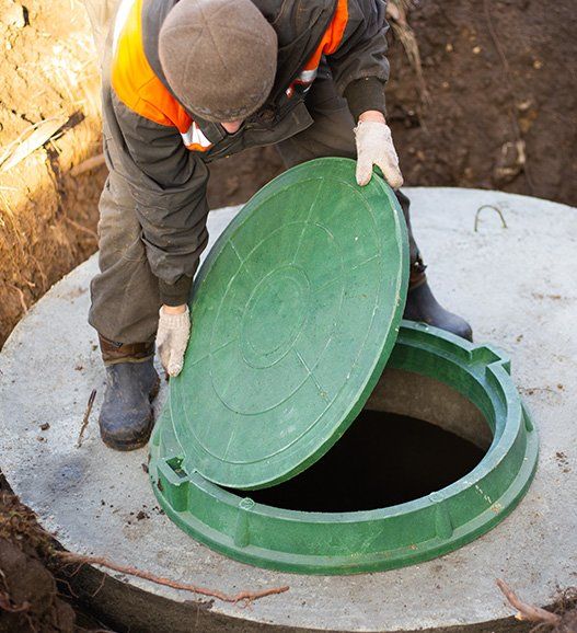 Worker Installs a Sewer Manhole on a Septic Tank — Crestview, FL — Madden Septic Service