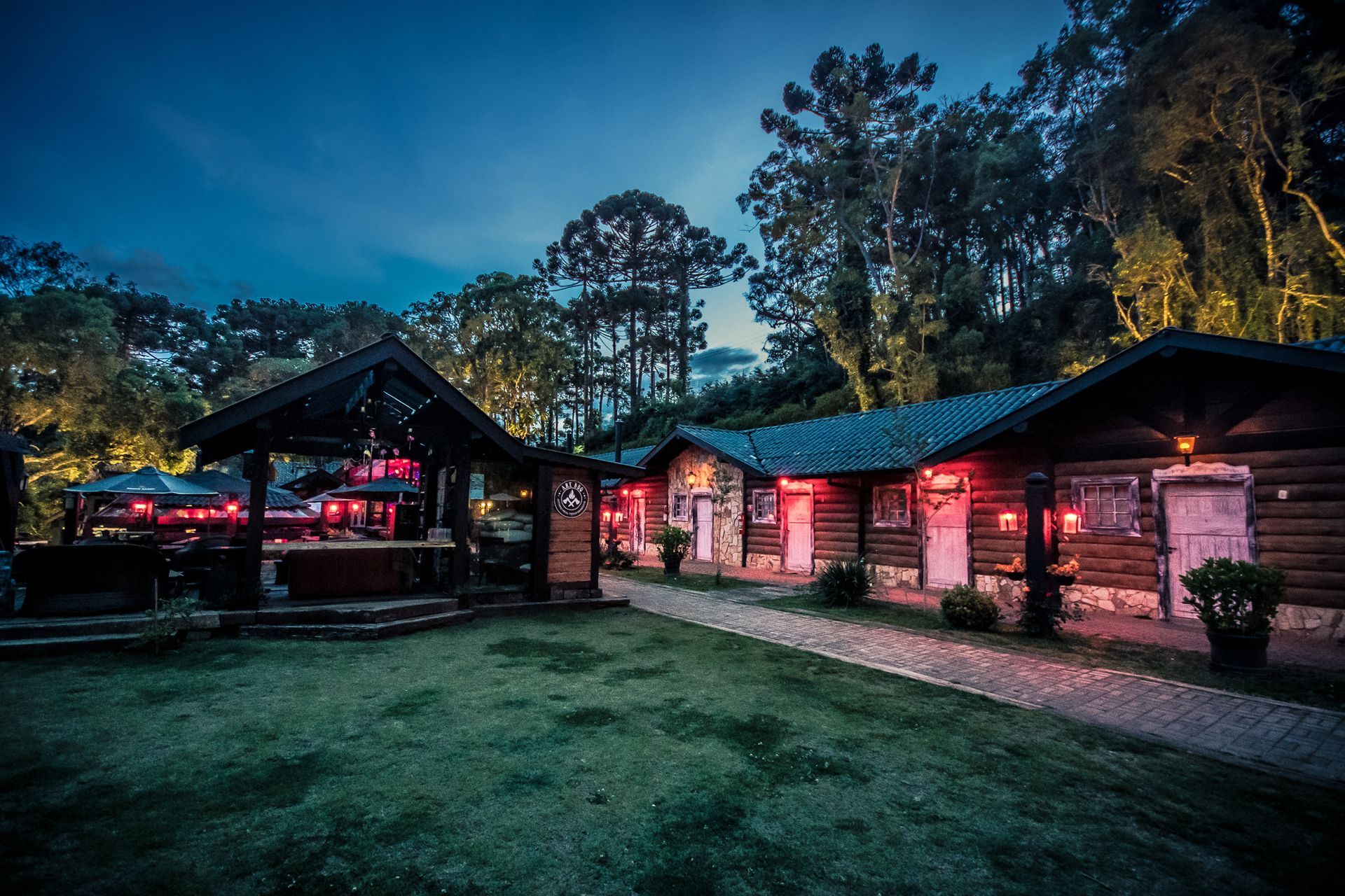 Um grupo de cabanas de madeira fica iluminado à noite.