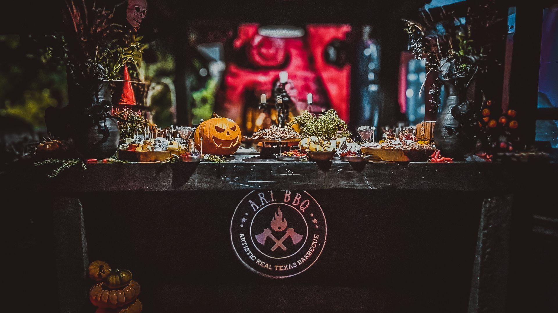 Uma mesa decorada para o Halloween com abóboras e um logotipo.