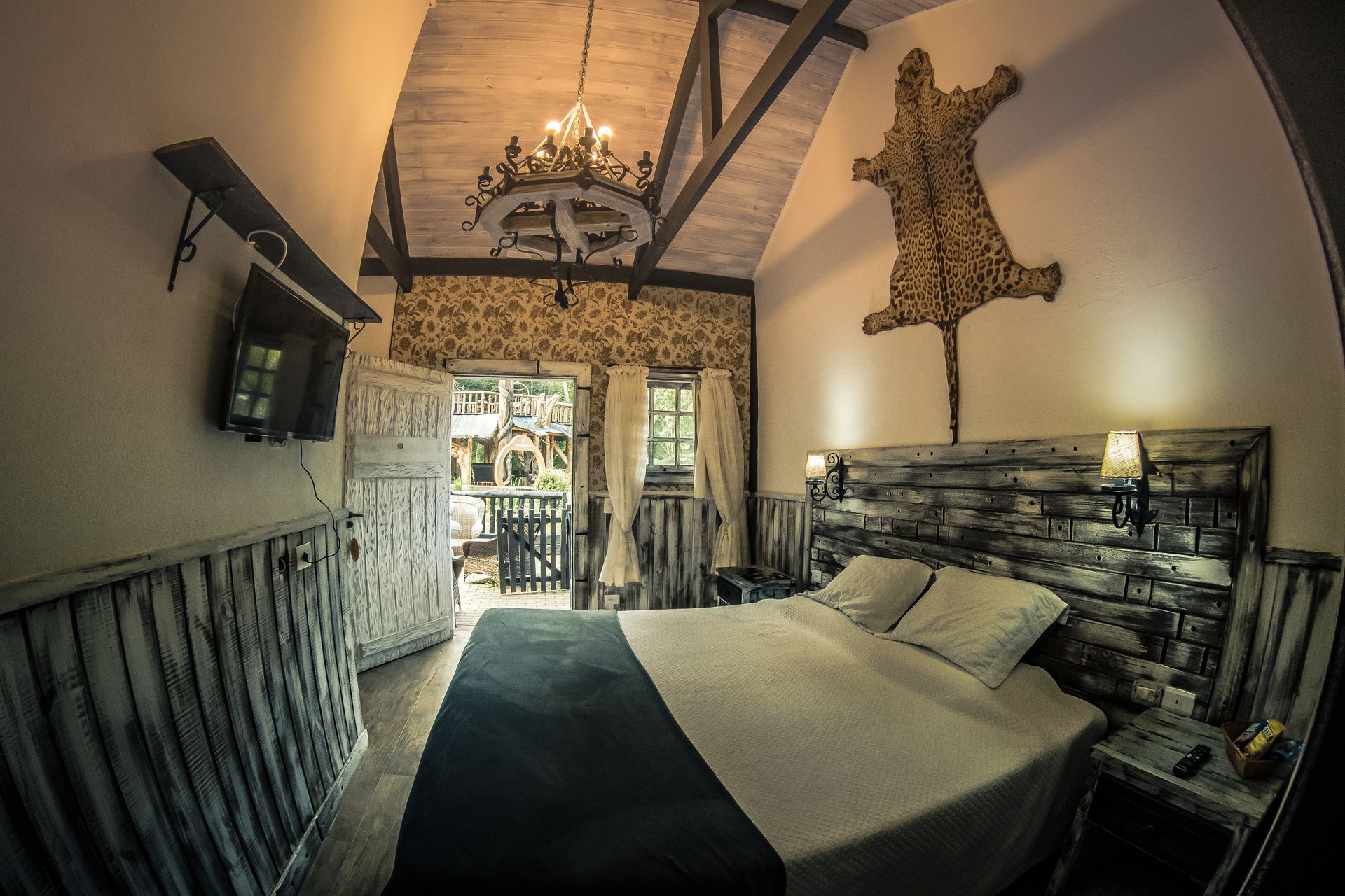 Um quarto com uma cama grande e uma estampa de leopardo na parede.