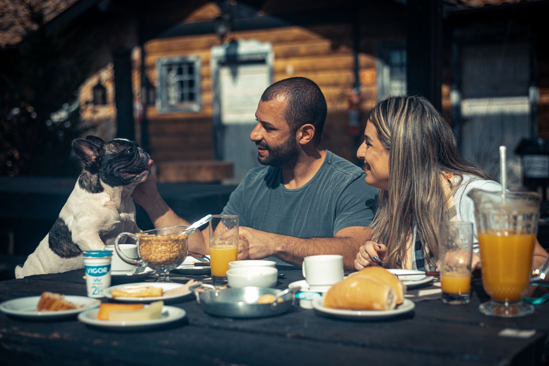 Um homem e uma mulher estão sentados à mesa com um cachorro.