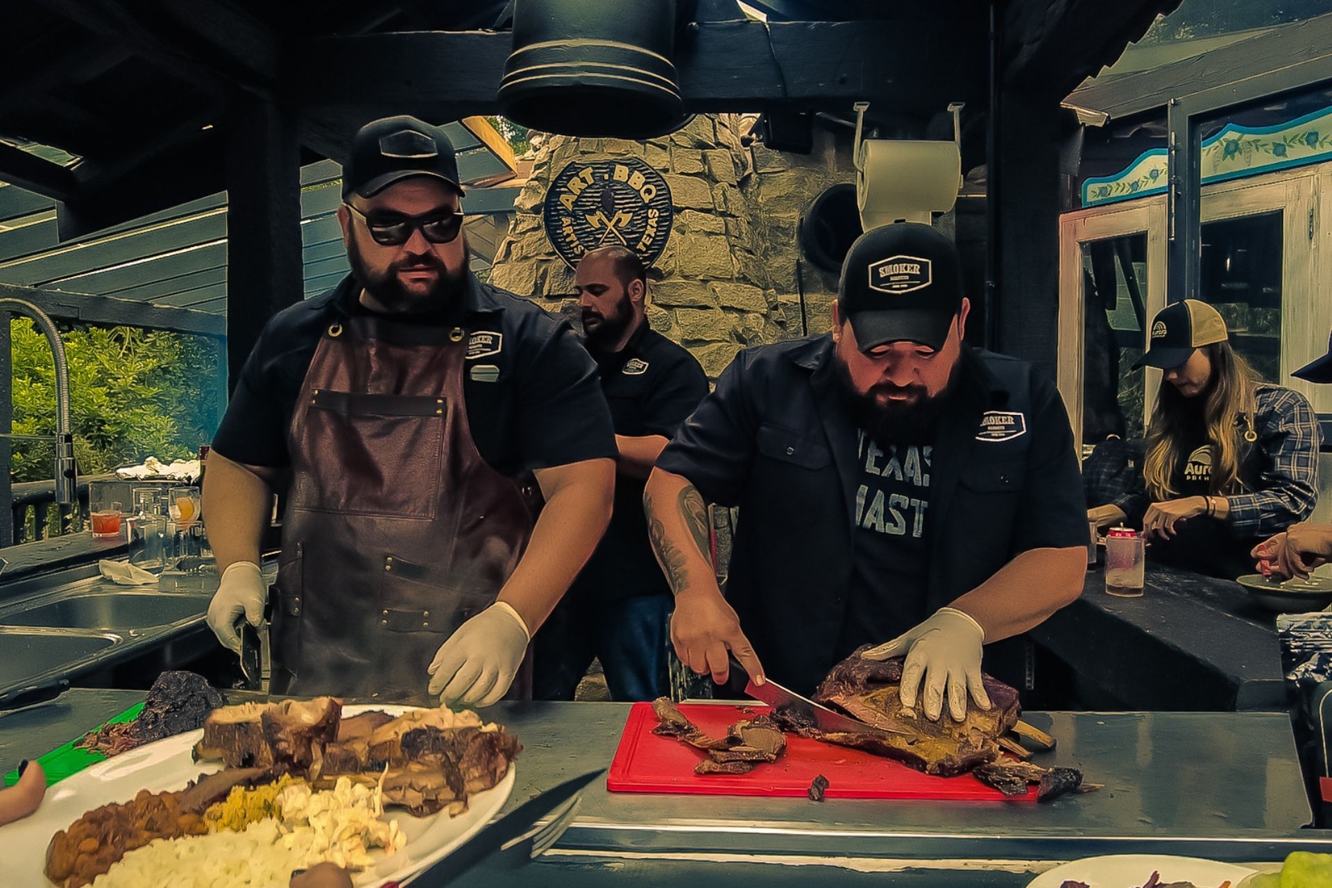 Dois homens estão cortando carne em uma tábua em um restaurante.