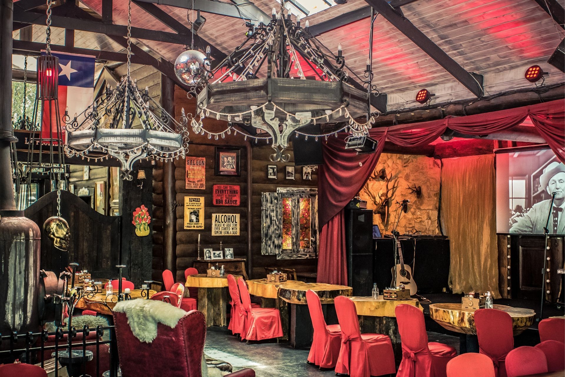 Um restaurante com cadeiras e mesas vermelhas e um lustre pendurado no teto.