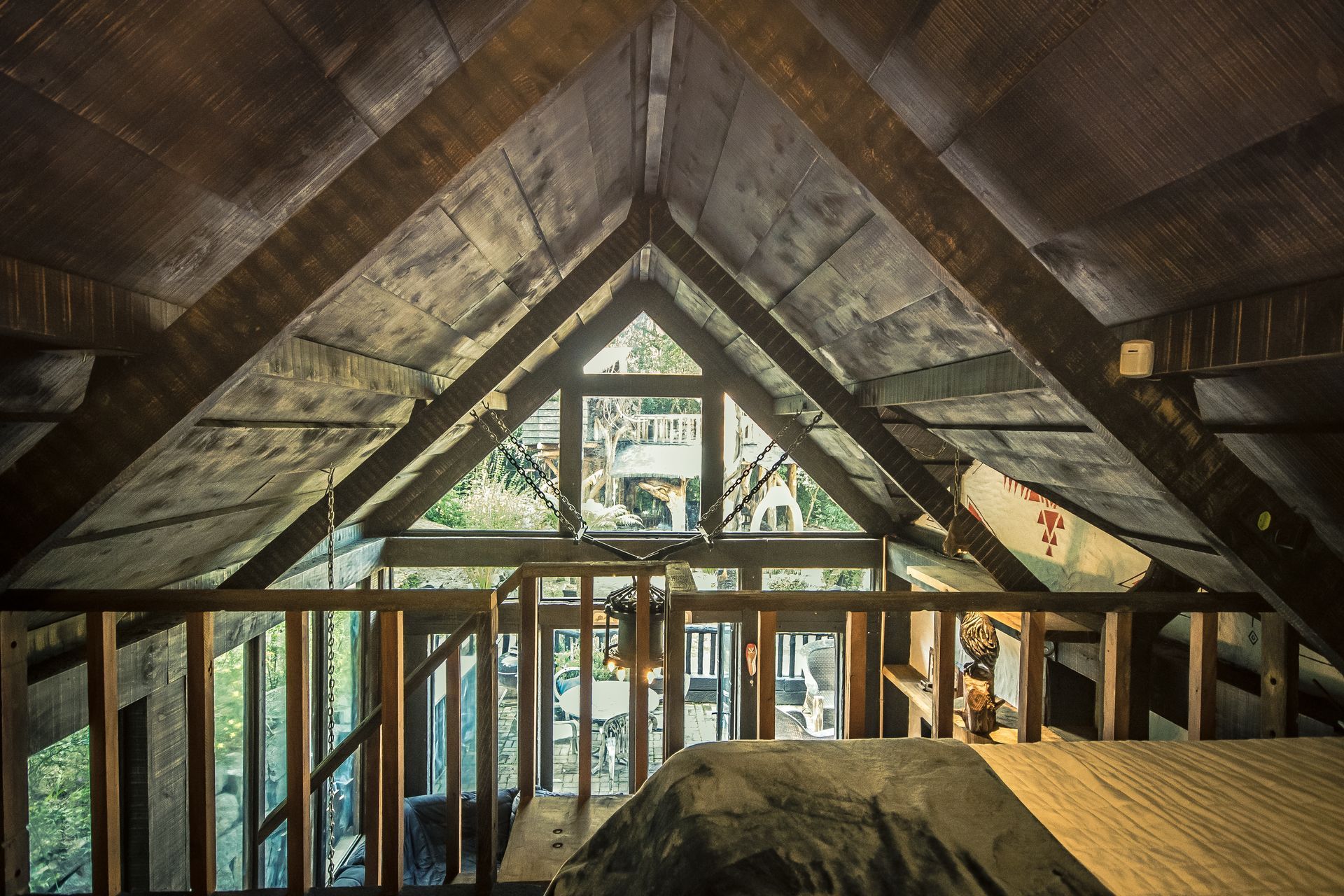 Um sótão com grade de madeira e uma grande janela
