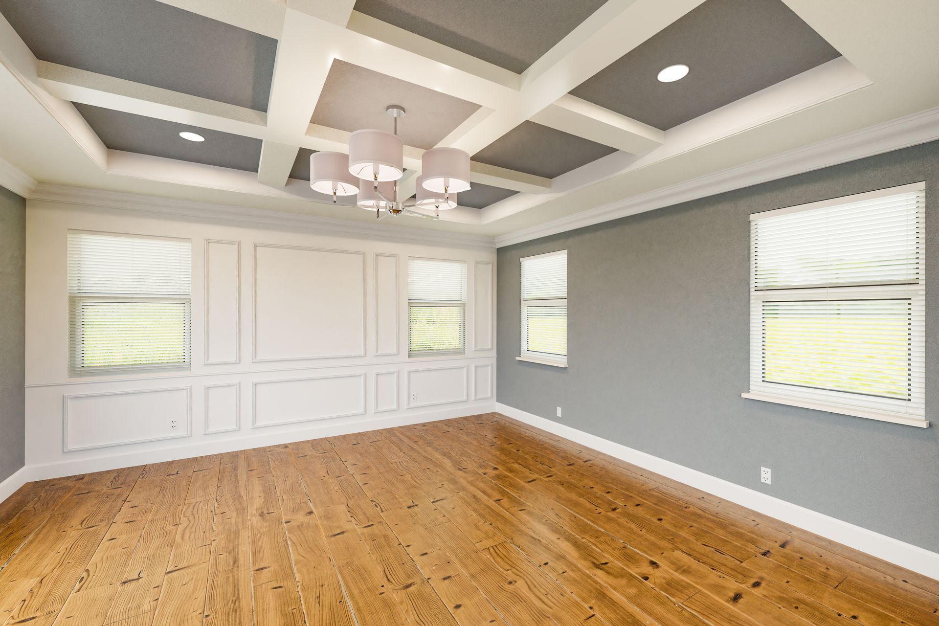 An empty room with hardwood floors and a coffered ceiling.