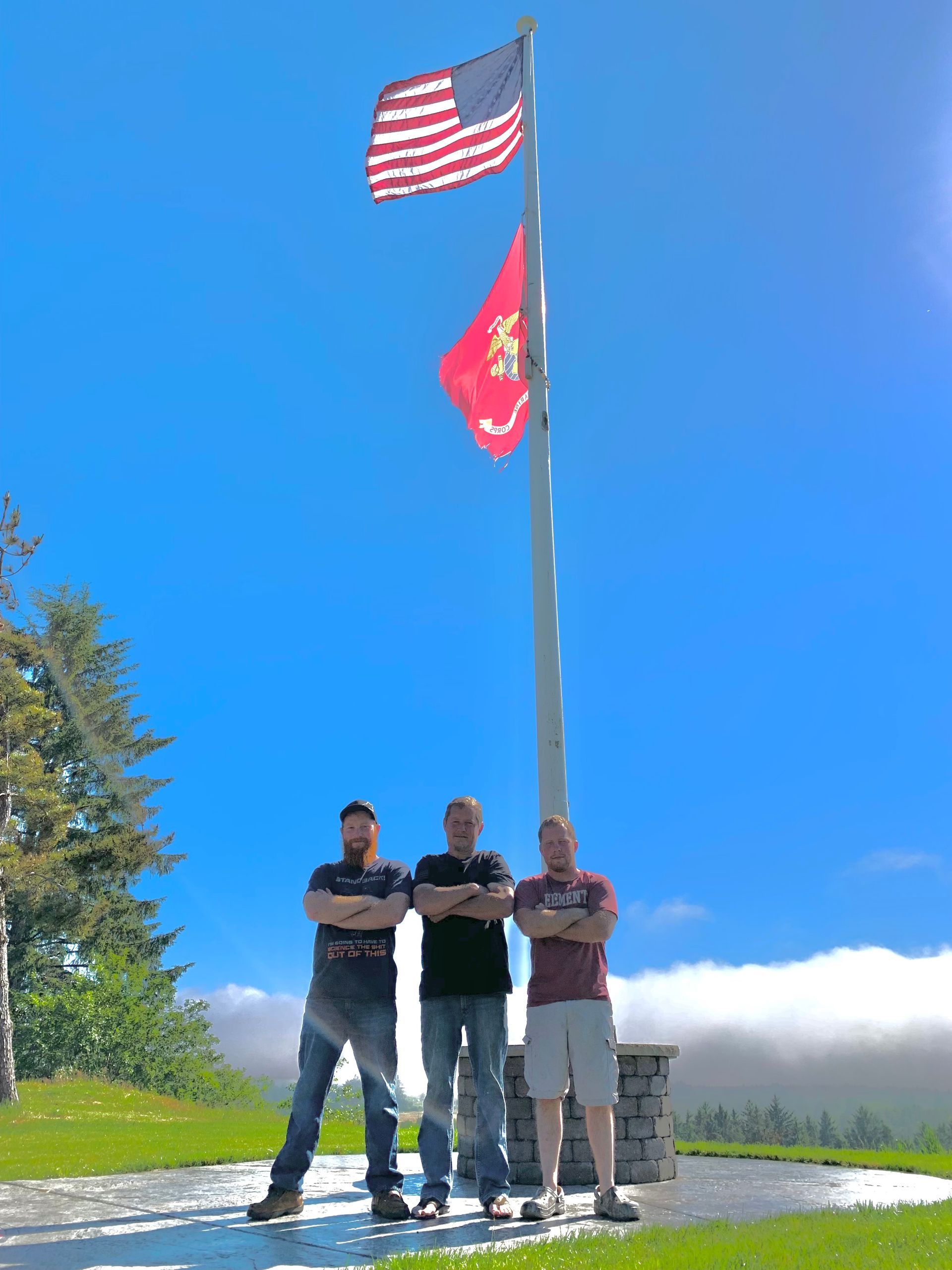 Three men standing in front of an american flag