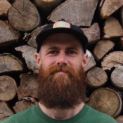 Un homme avec une barbe portant un chapeau sur lequel est écrit « vans »