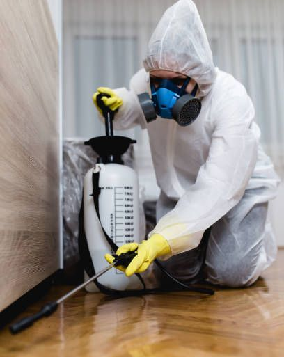 Technician wearing gas mask preparing chemical spray.