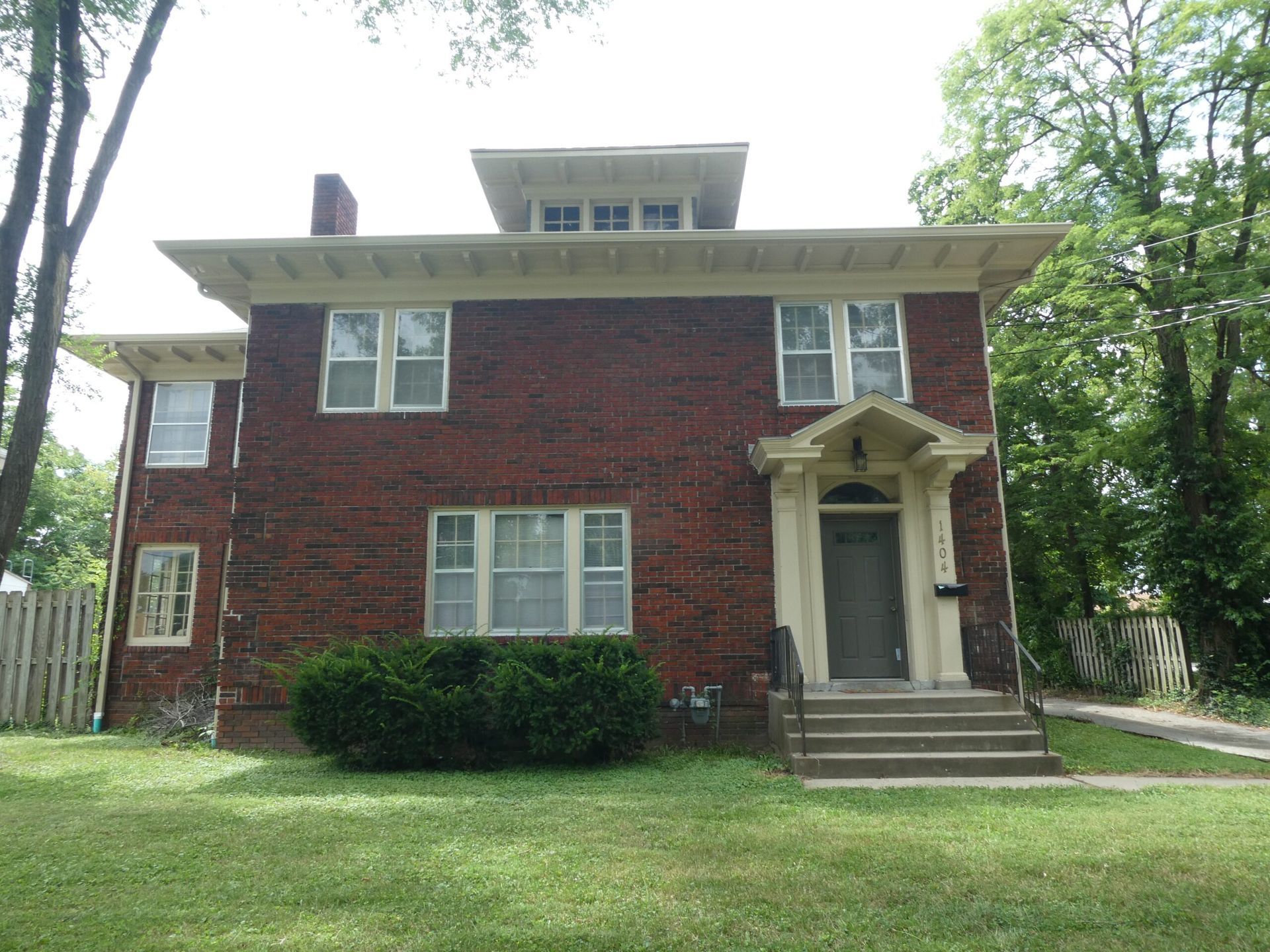 A large brick house with a porch and stairs