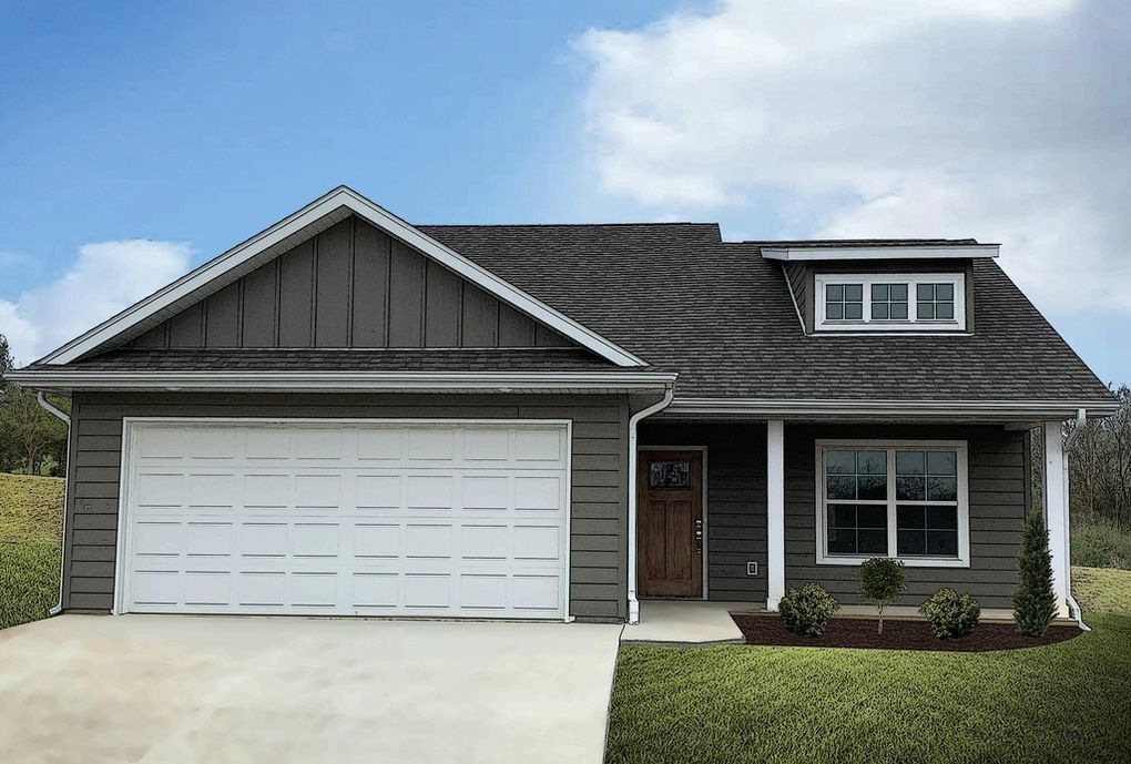 A gray house with a white garage door and a porch.