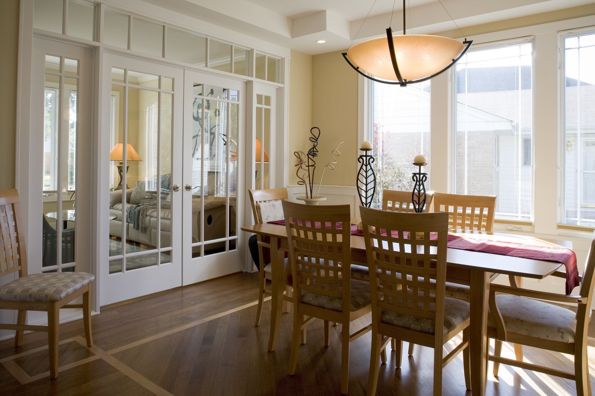 A dining room with a table and chairs and sliding glass doors