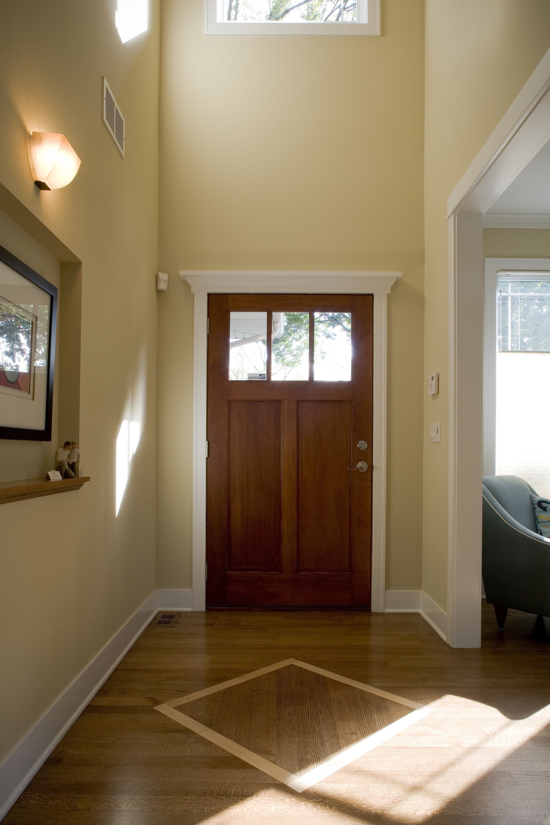 A hallway with a wooden door and a window