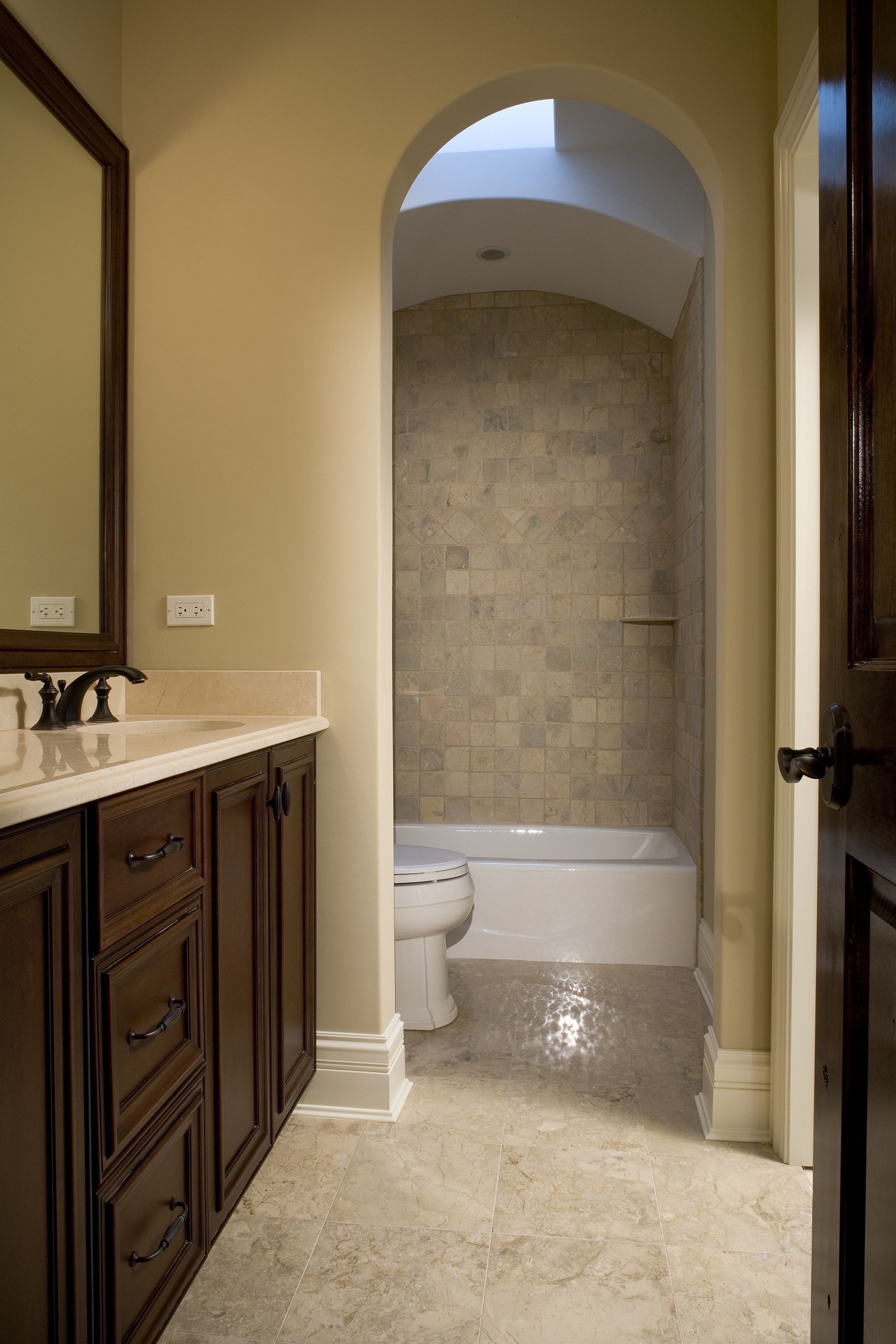 A bathroom with a toilet , sink , mirror and bathtub.