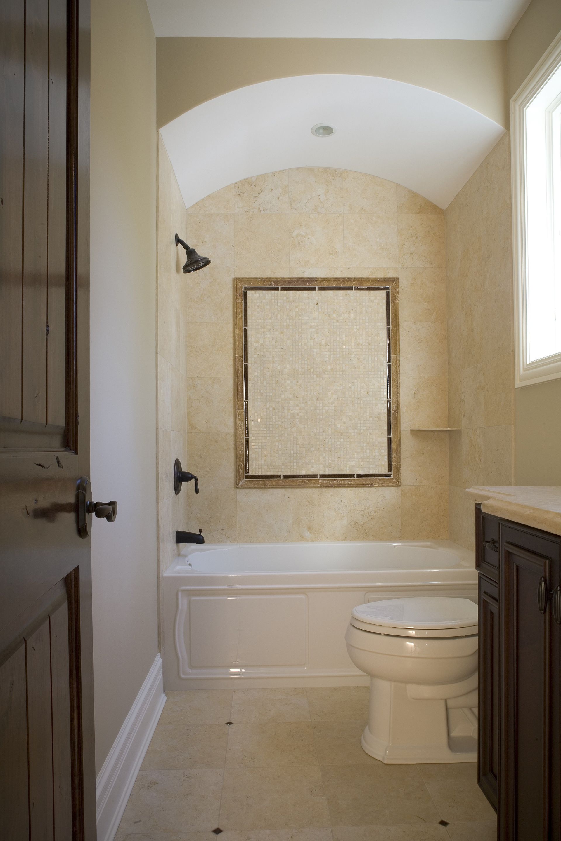 A bathroom with a toilet , bathtub and mirror