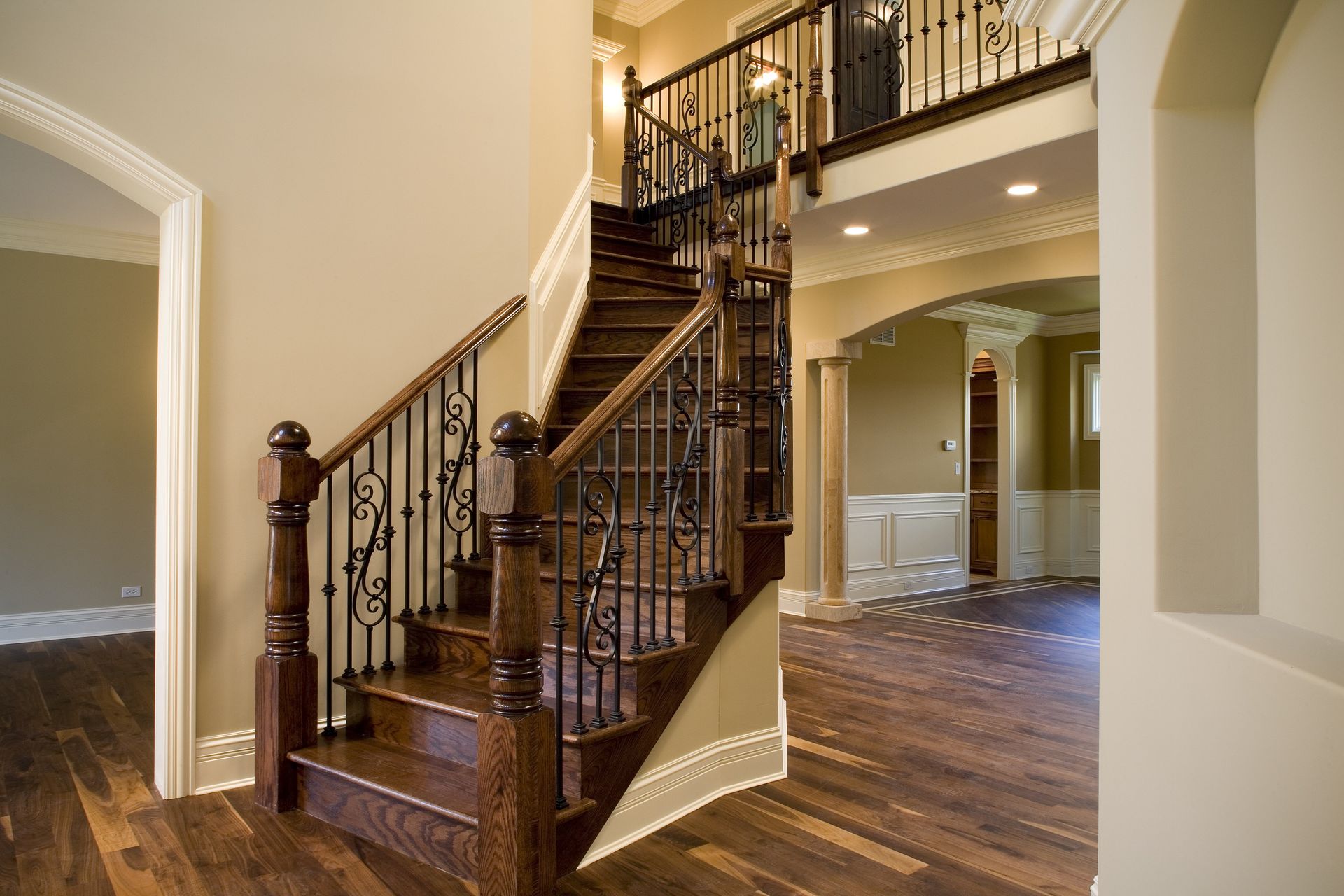 A wooden staircase with a wrought iron railing in a house