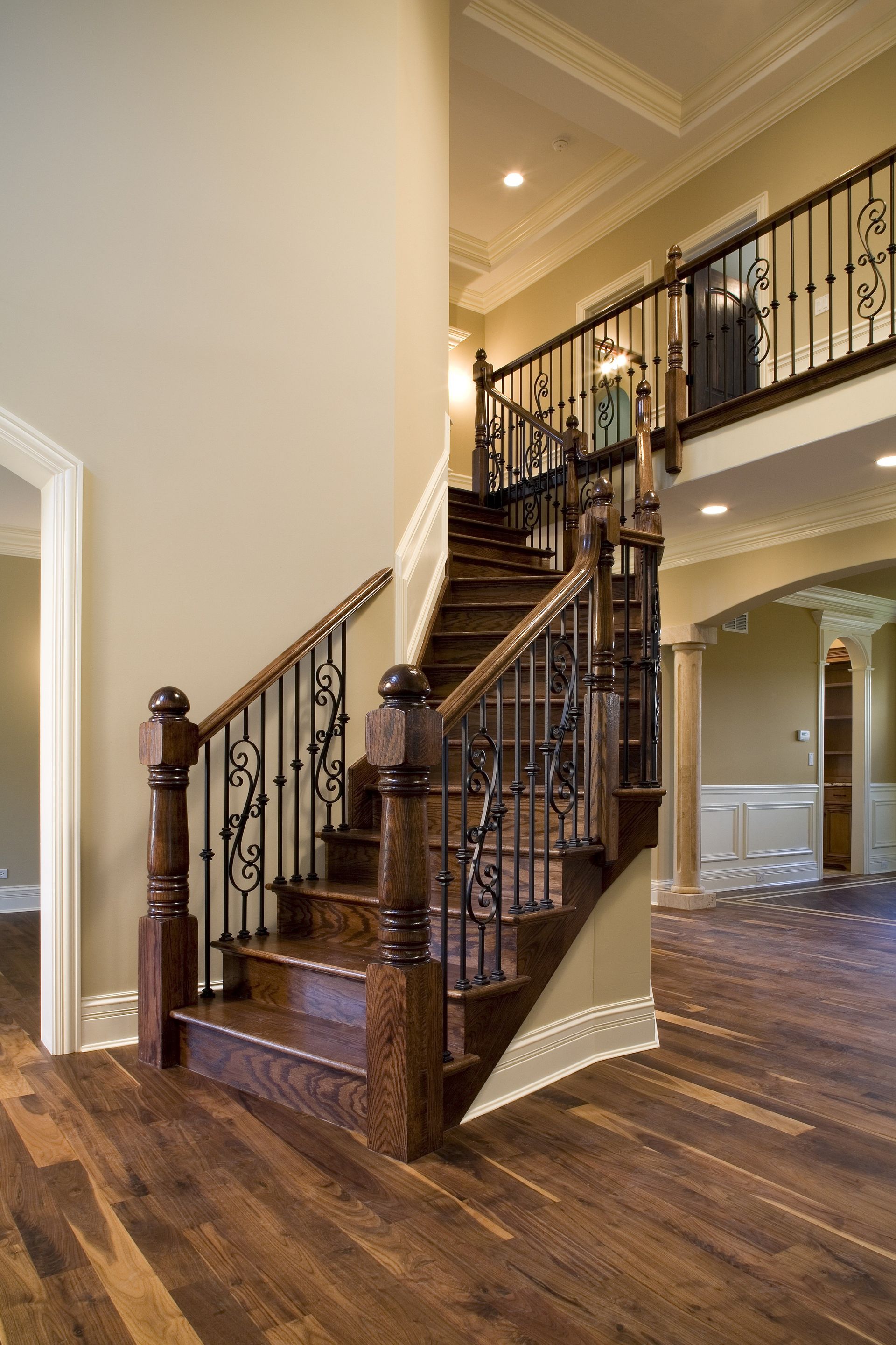 A wooden staircase with a wrought iron railing in a house