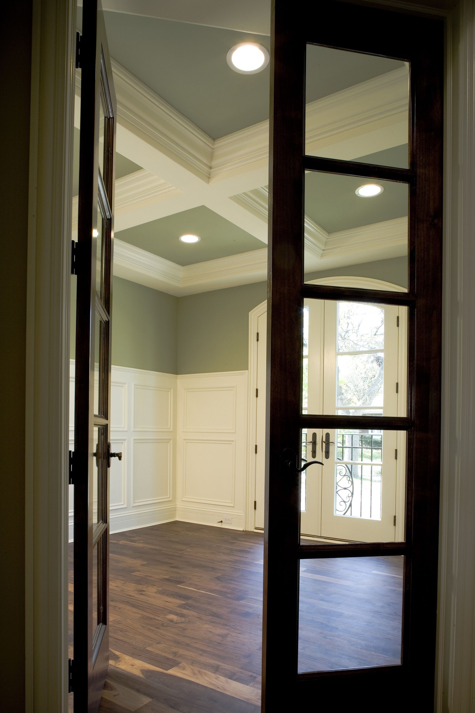 An empty room with a wooden floor and a glass door