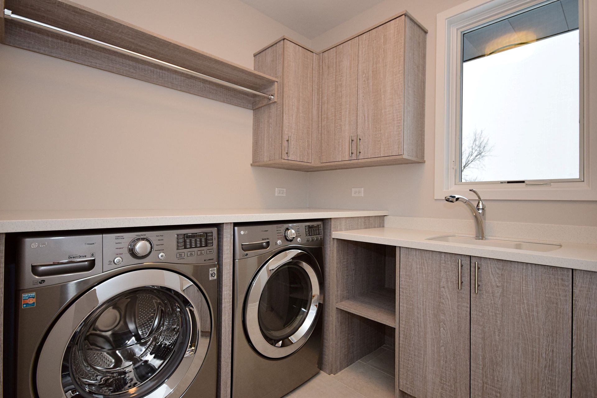 A laundry room with a washer and dryer and a sink.