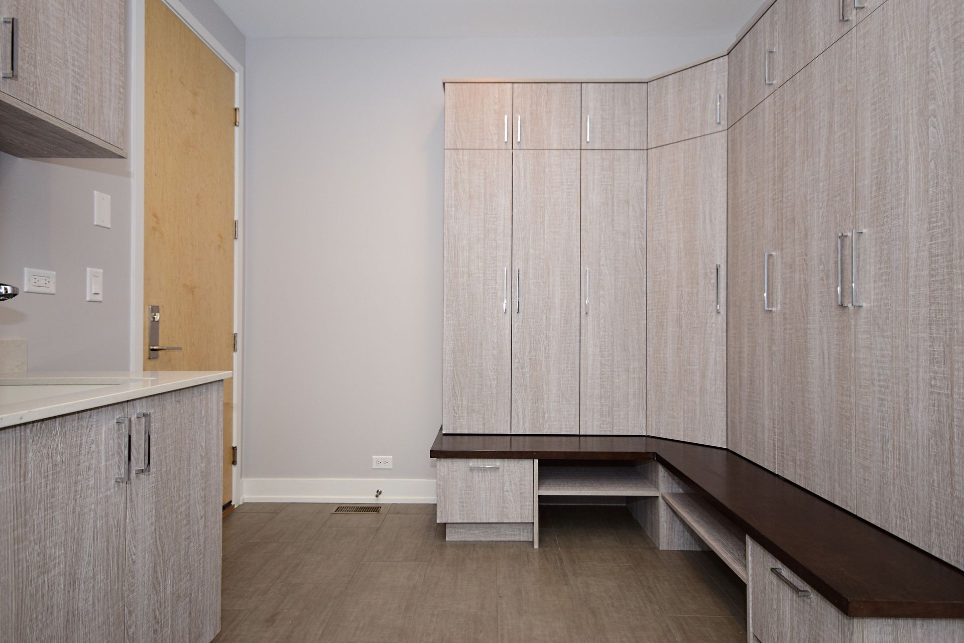 An empty room with lots of cabinets and a bench