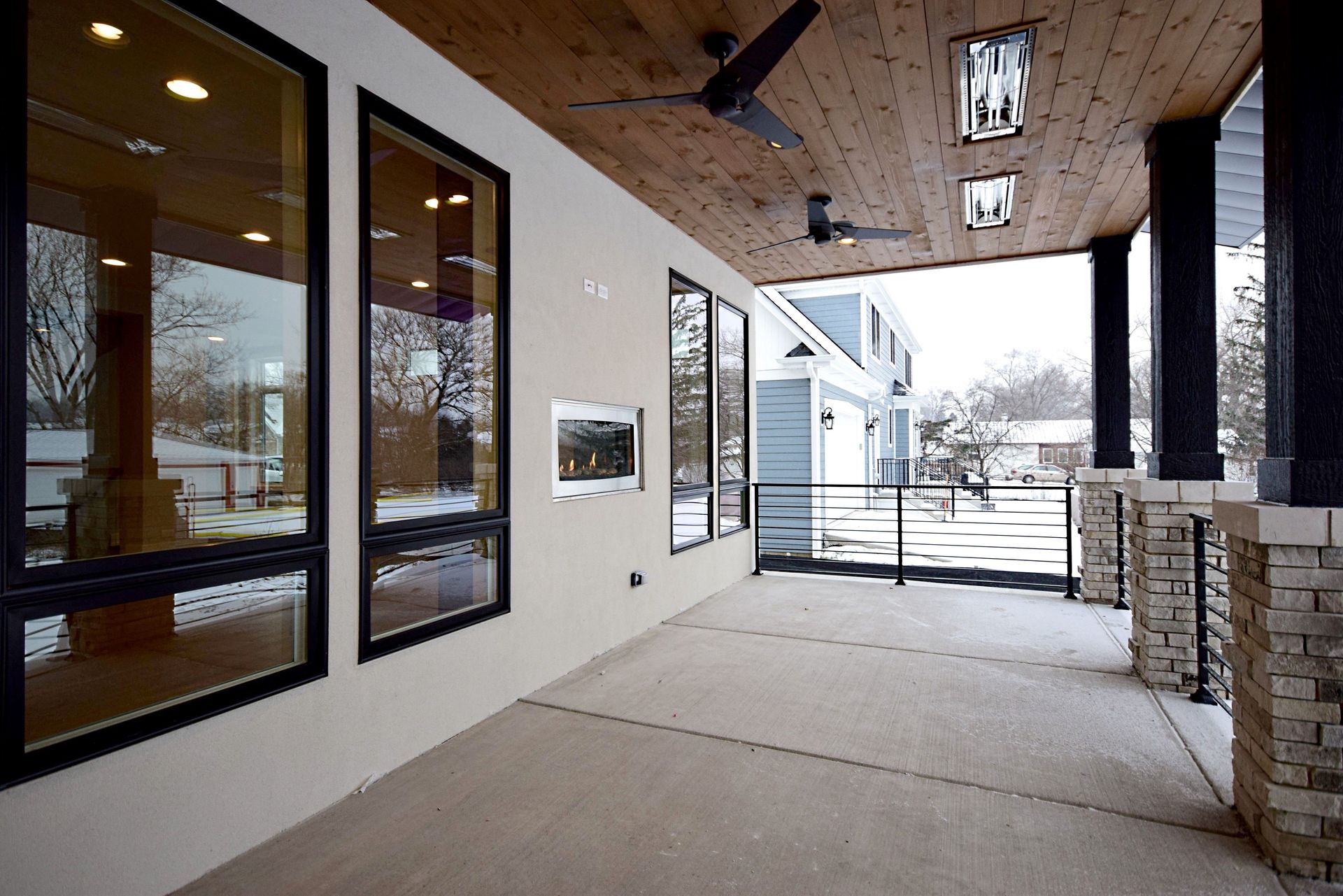 A large porch with a lot of windows and a ceiling fan