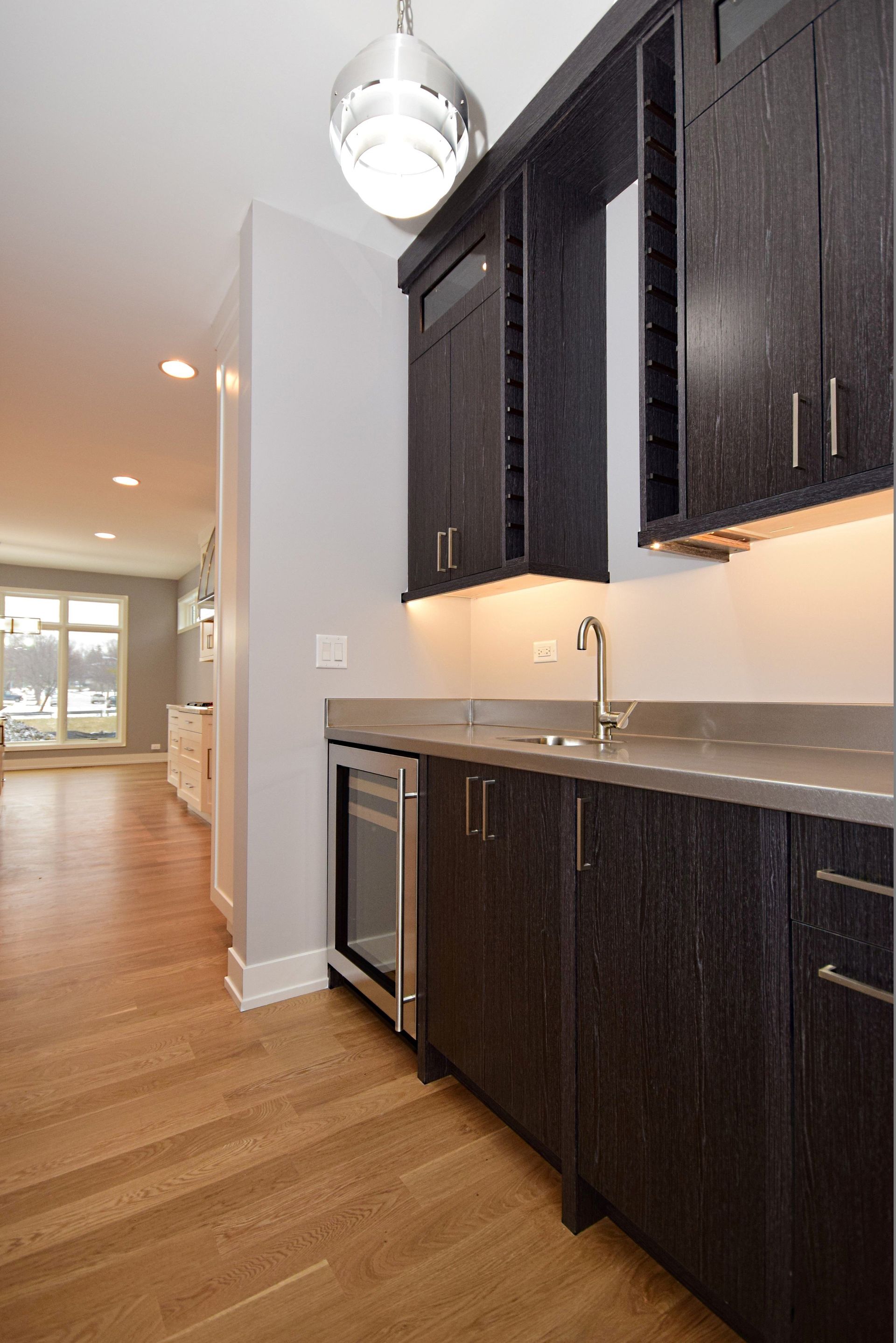 A kitchen with black cabinets and stainless steel appliances