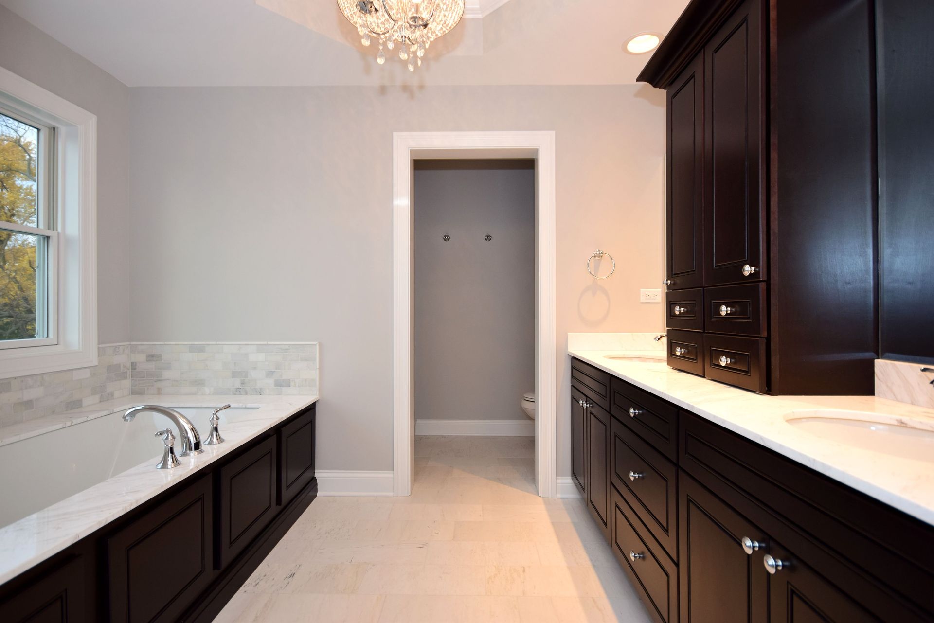 A bathroom with black cabinets and a bathtub.