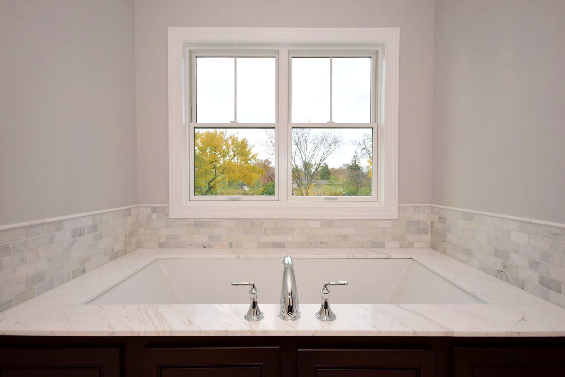 A bathroom with a bathtub and a window.