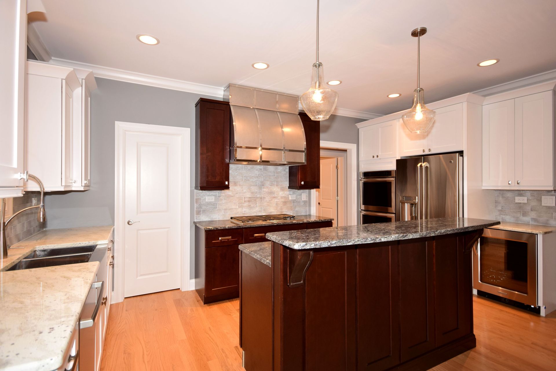 A kitchen with stainless steel appliances and a large island in the middle.