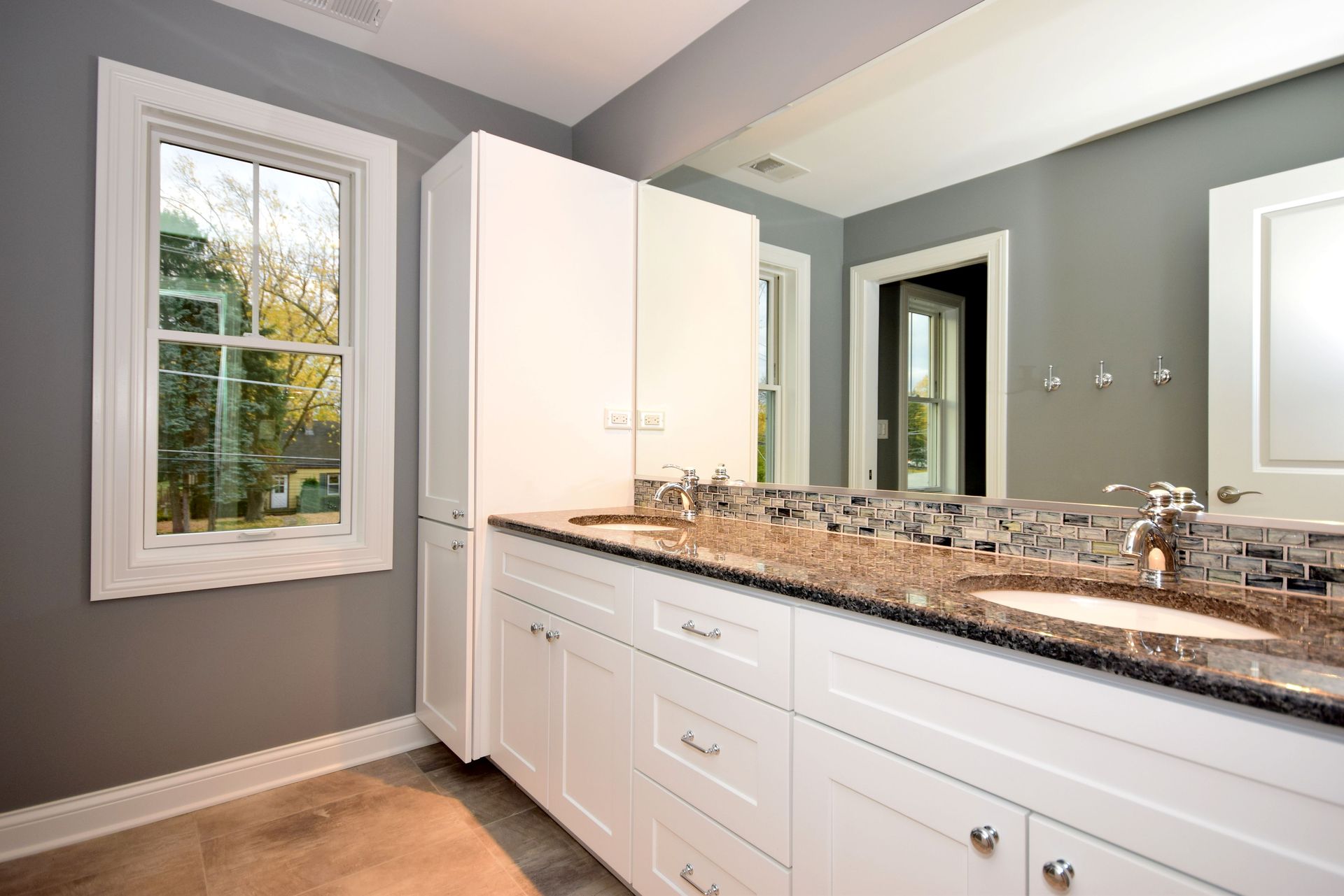 A bathroom with two sinks and a large mirror.