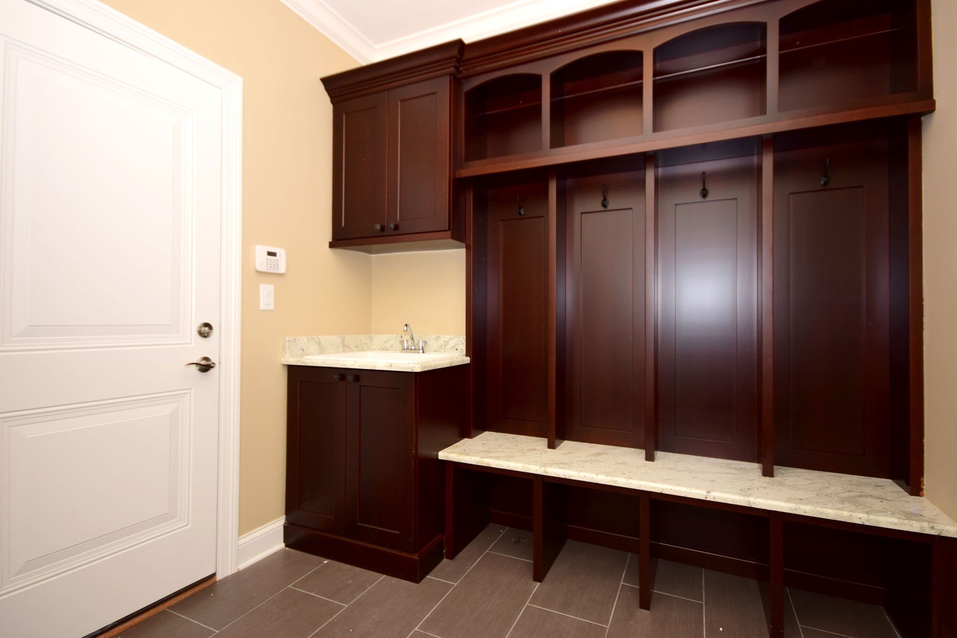 A mud room with wooden cabinets and a bench