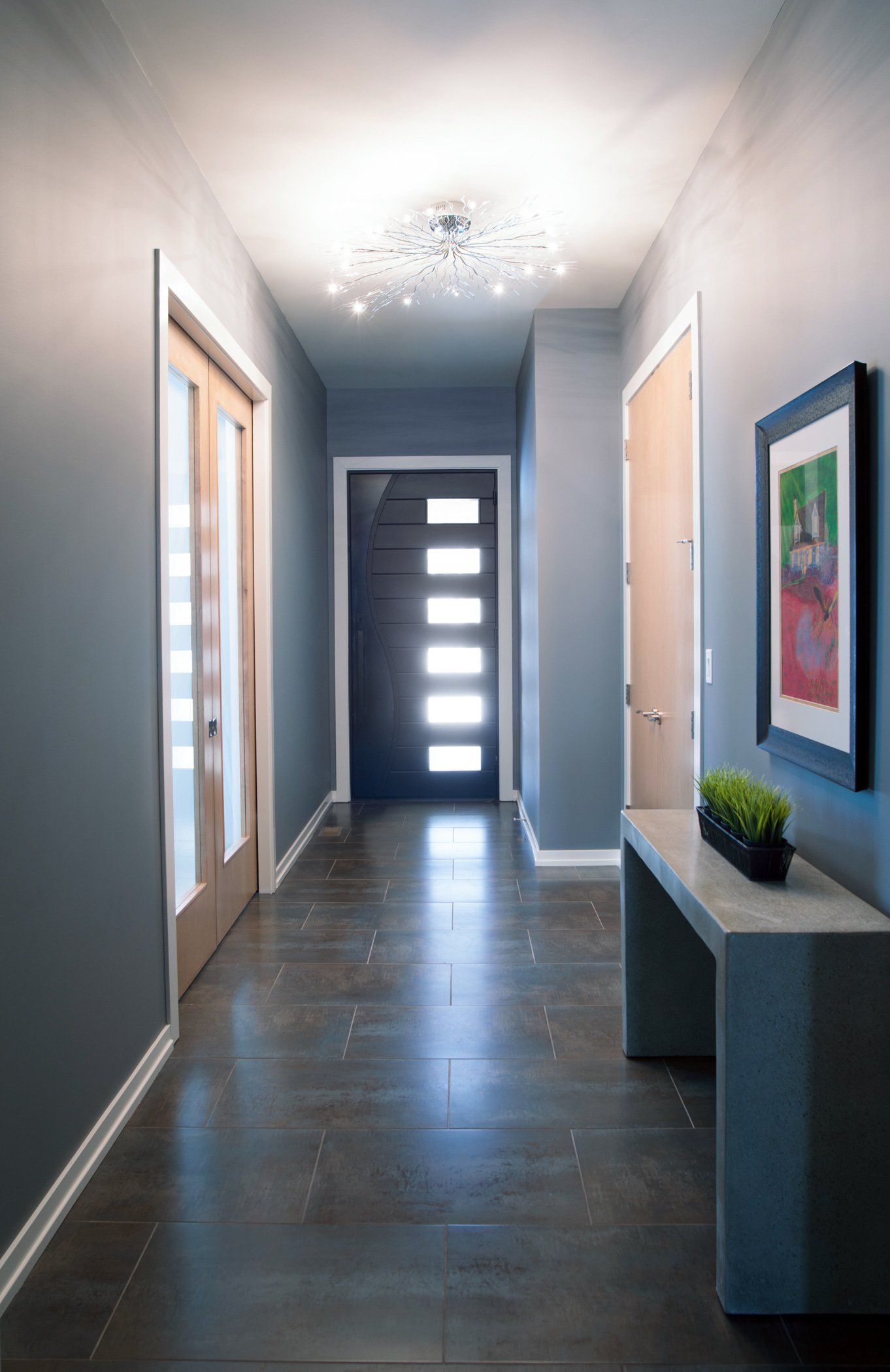 A hallway with a table and a picture on the wall.