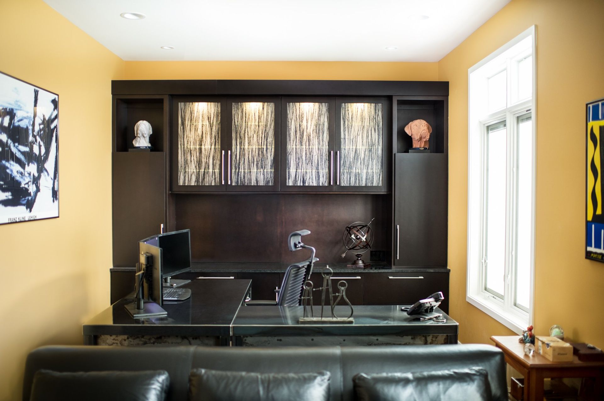 A living room with a couch and a desk with a computer on it.