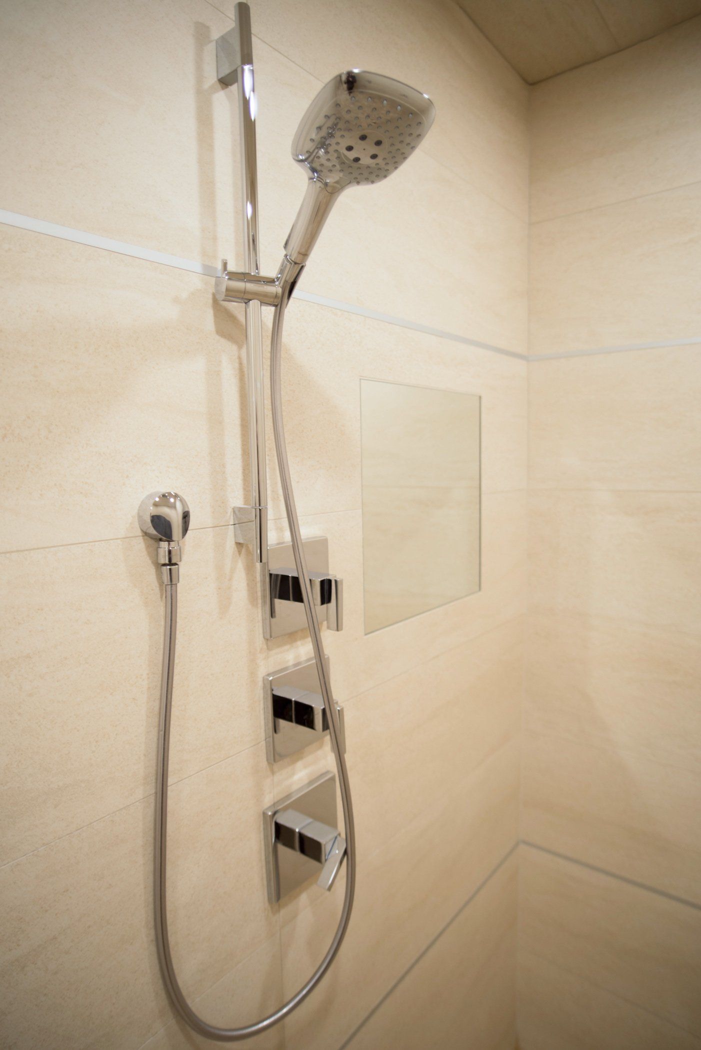 A close up of a shower head in a bathroom.