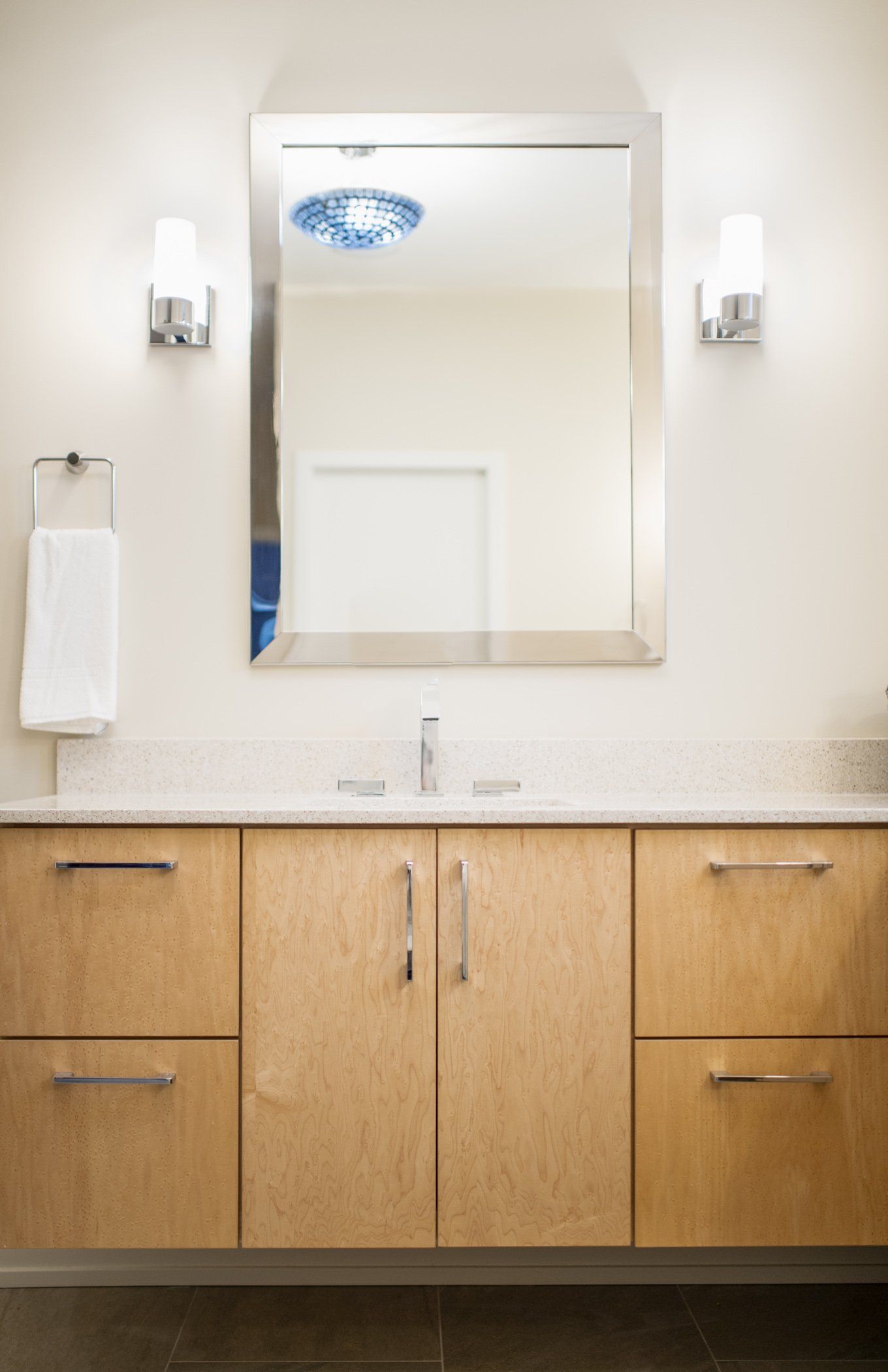 A bathroom with wooden cabinets and a large mirror