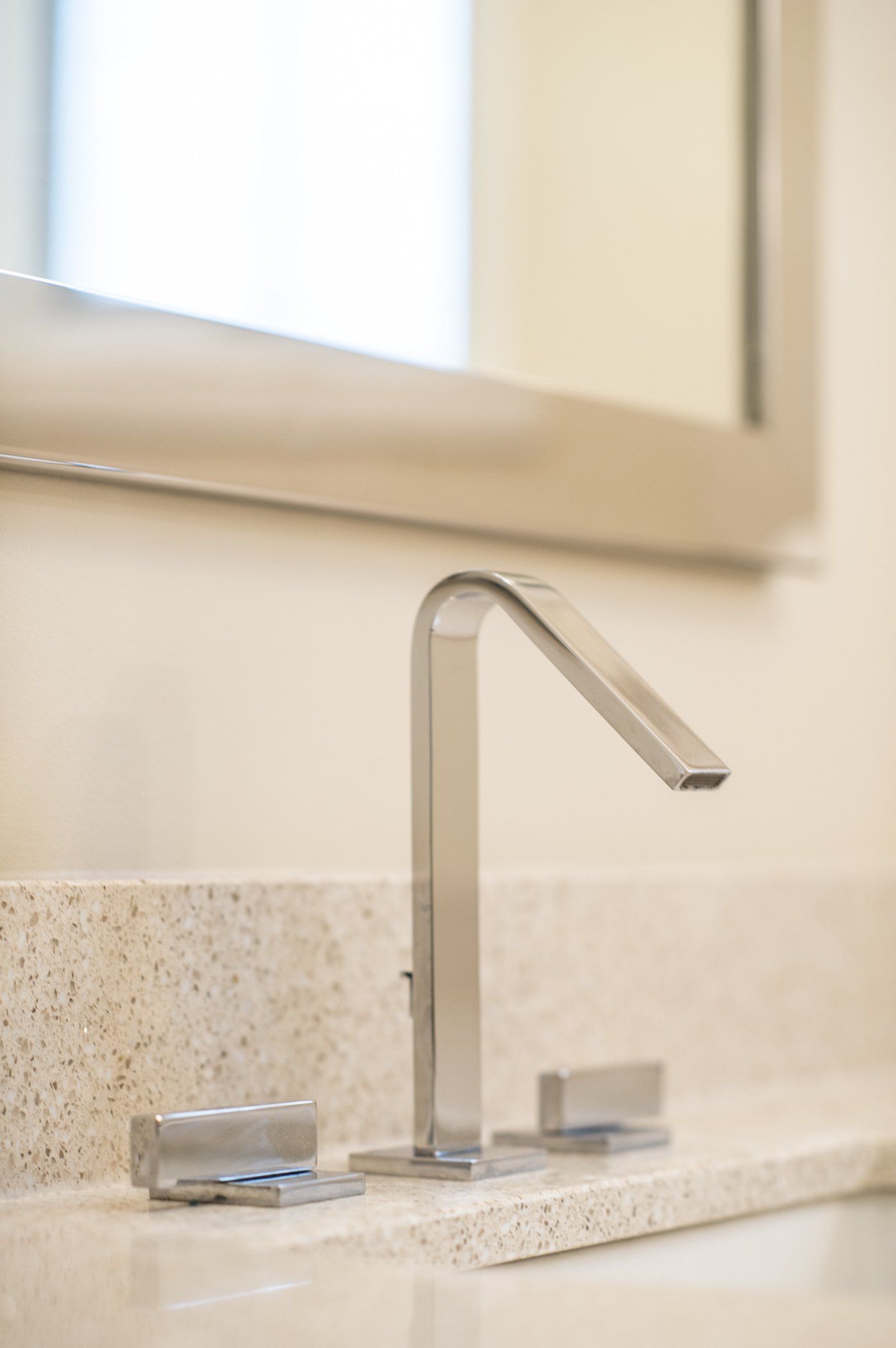 A bathroom sink with a faucet and a mirror.