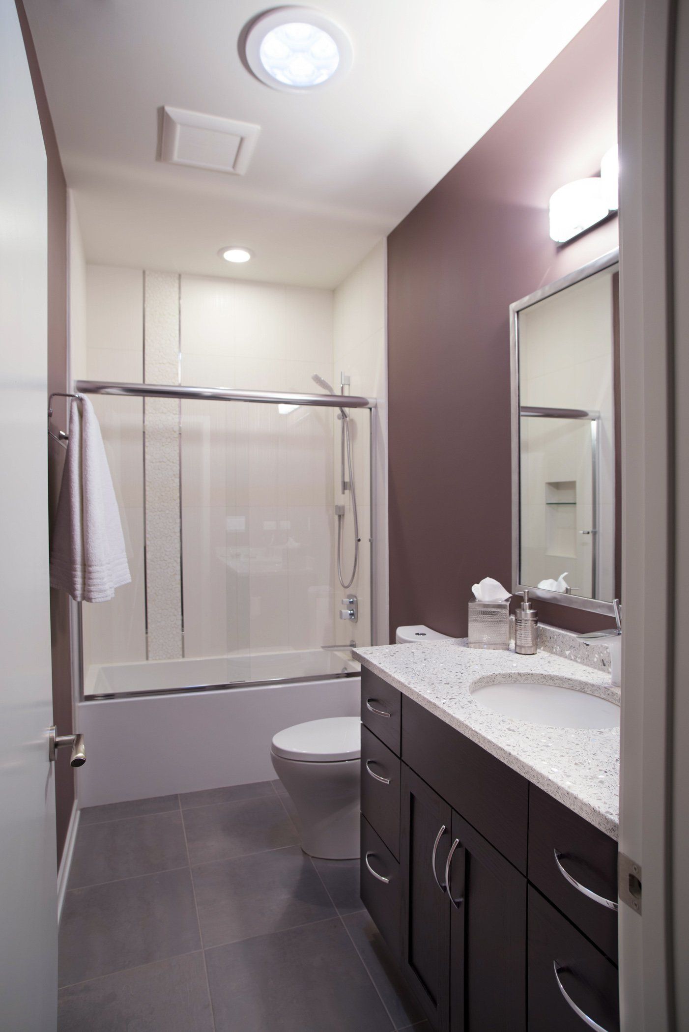 A bathroom with a toilet a sink and a mirror