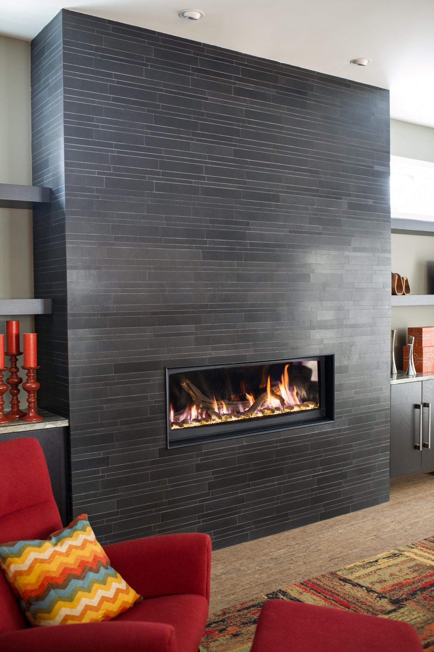 A living room with a fireplace and a red chair.